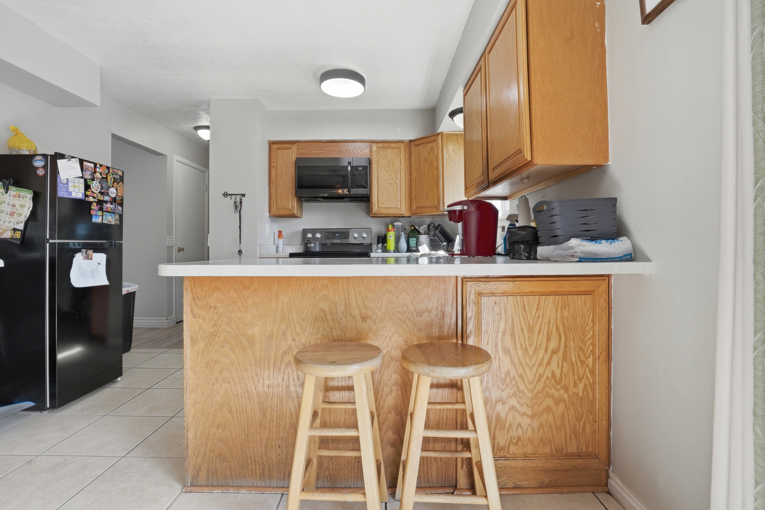 Kitchen featuring wood-finish cabinetry, solid surface countertops, and tile flooring