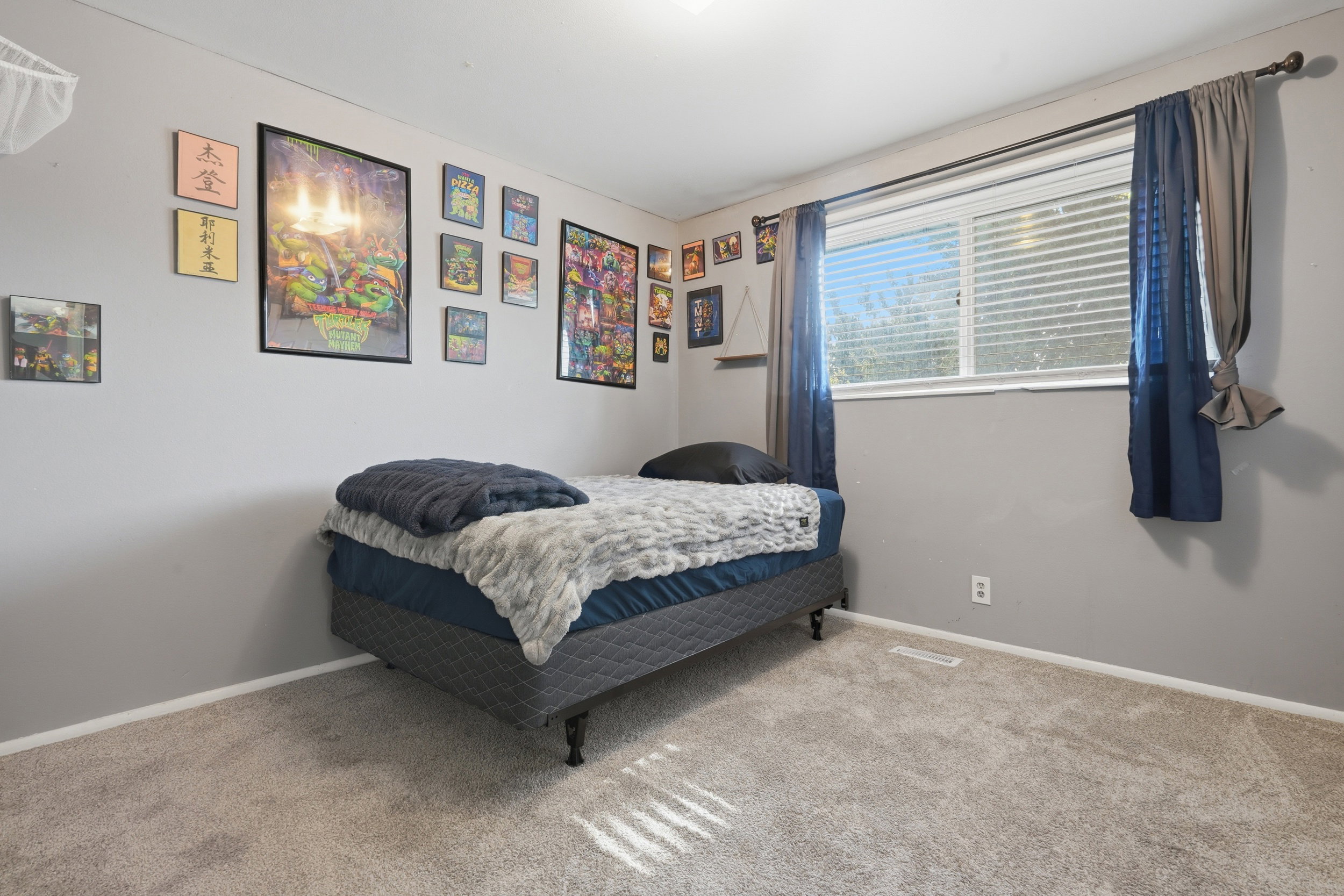 Carpeted room featuring a large window with horizontal blinds, light gray wall paint, and white baseboards