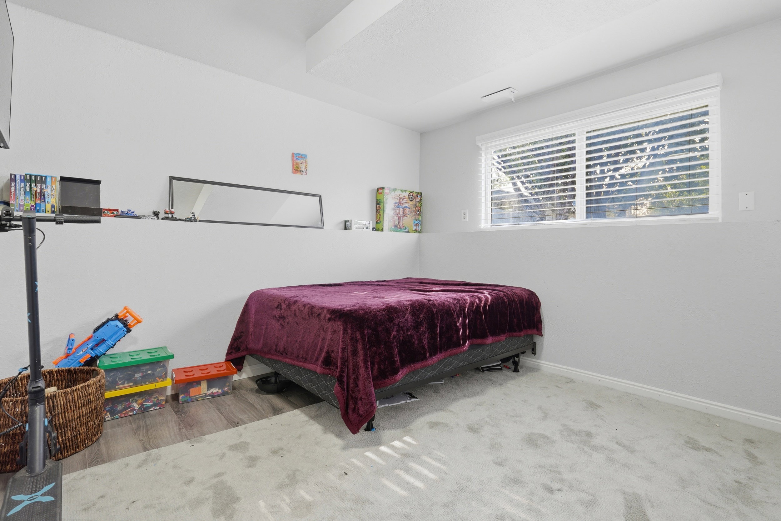 Neutral-toned room with a large window featuring horizontal blinds
