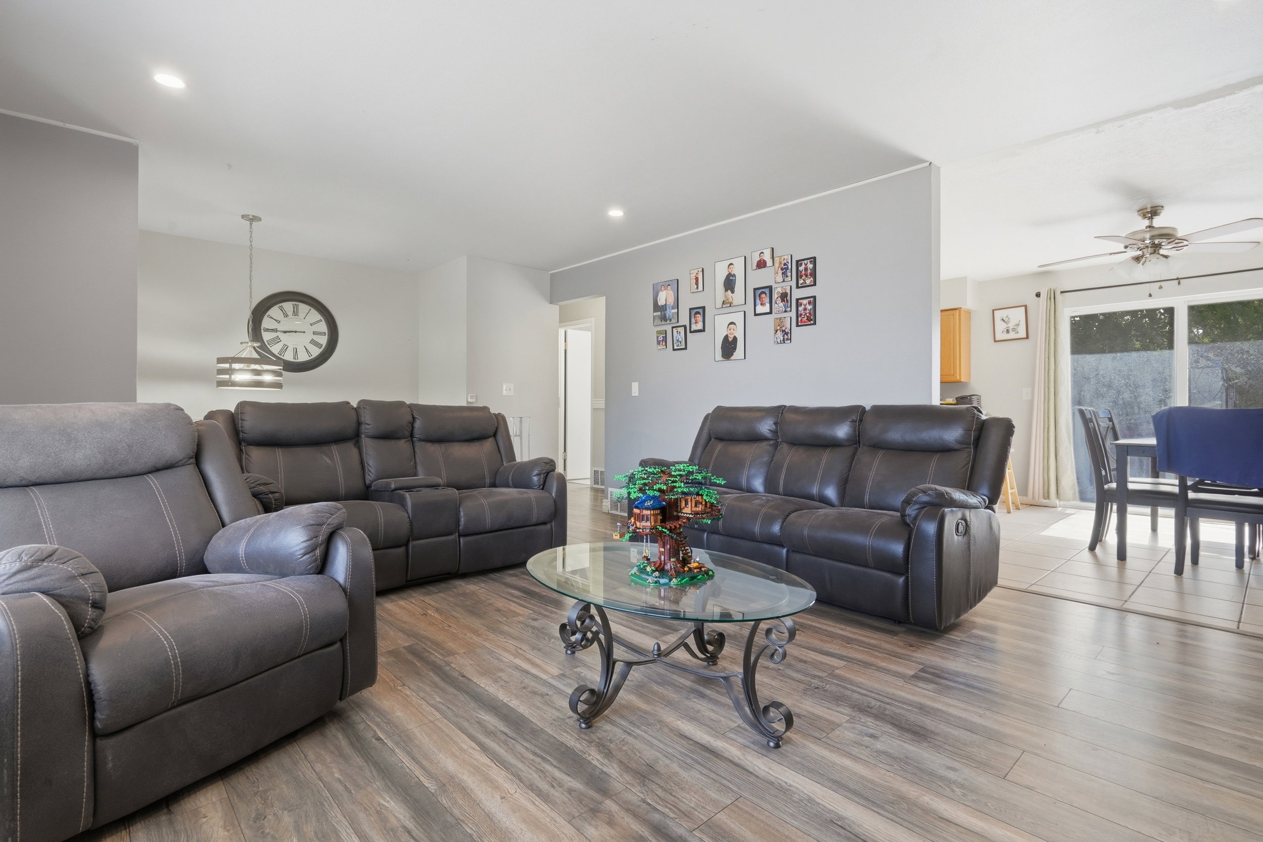 Spacious living area featuring wood-finish flooring, recessed lighting, and a modern pendant light fixture