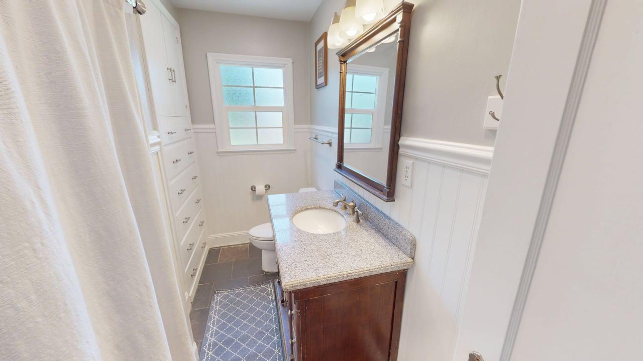 Bathroom featuring a wood vanity with a granite countertop and under-mount sink