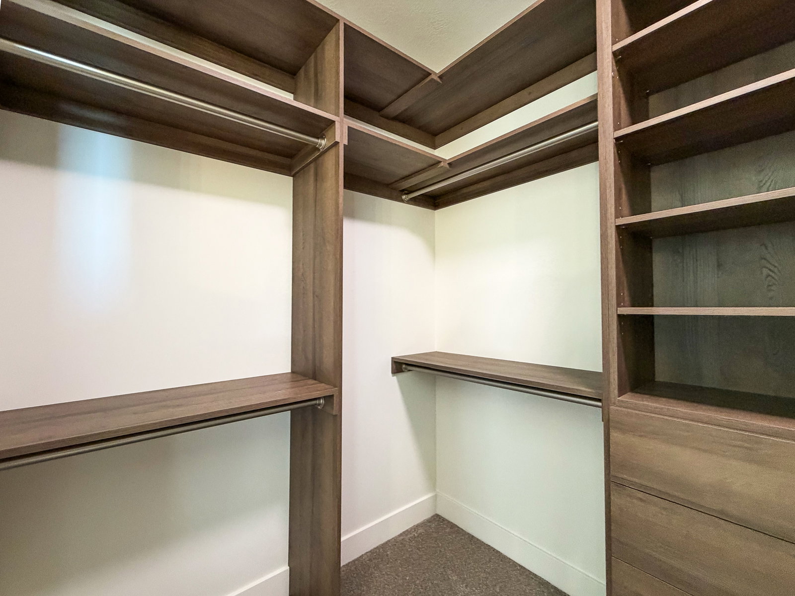 Custom closet system featuring wood-finish shelving, integrated hanging rods, and built-in drawers