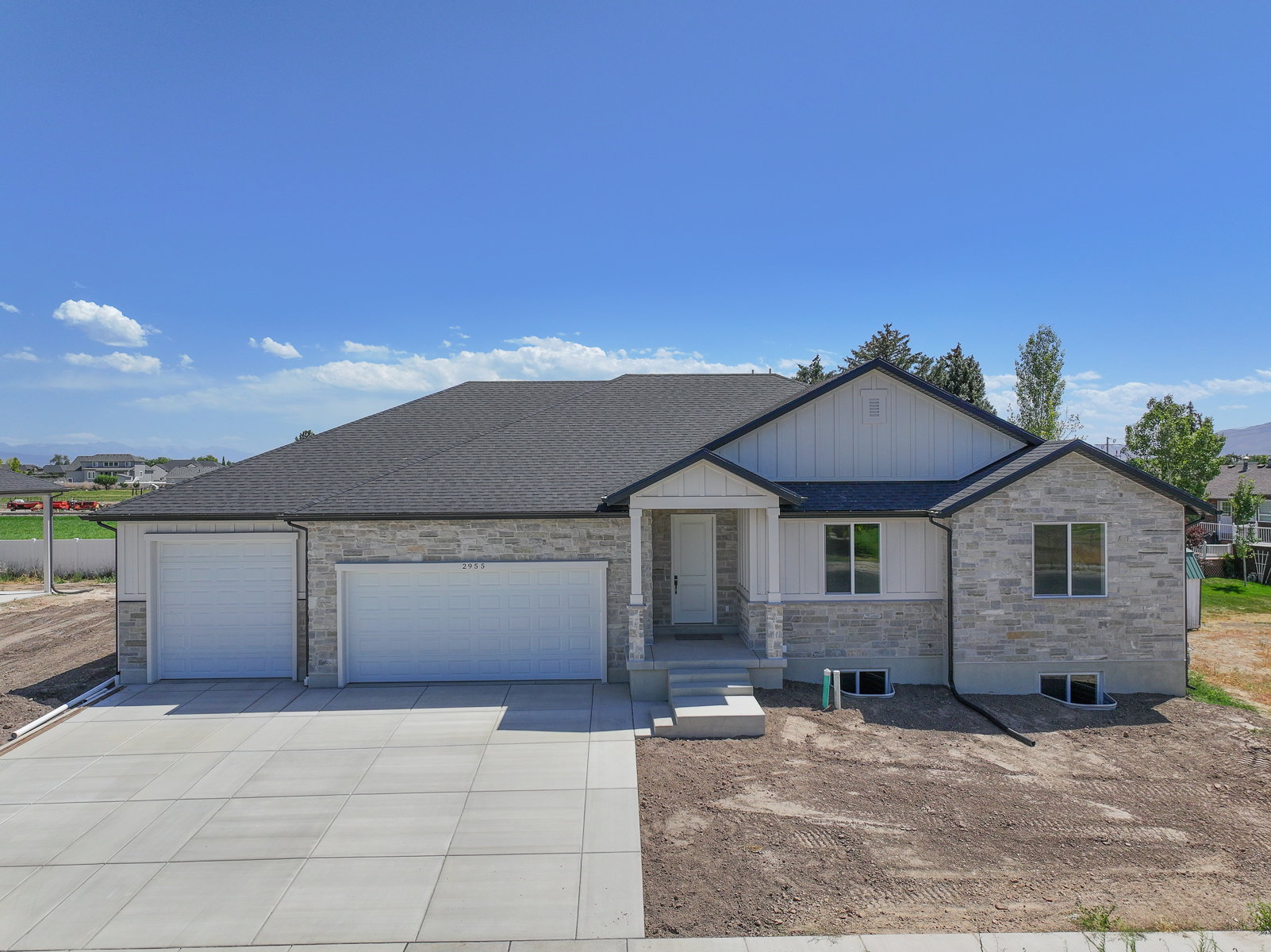 Contemporary residence featuring a multi-tone stone and white siding exterior