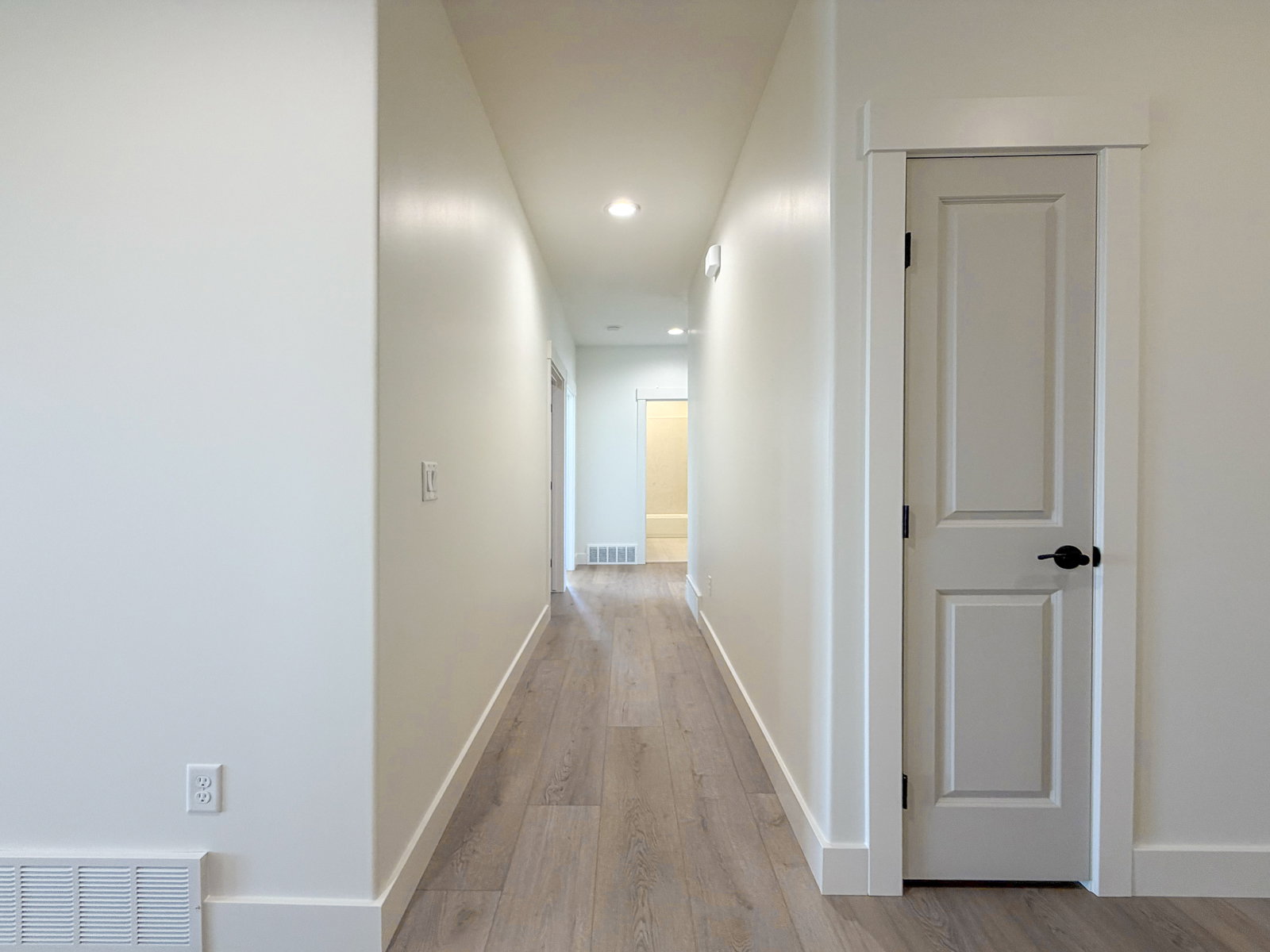Hallway featuring light wood-finish flooring, recessed lighting, and white baseboards