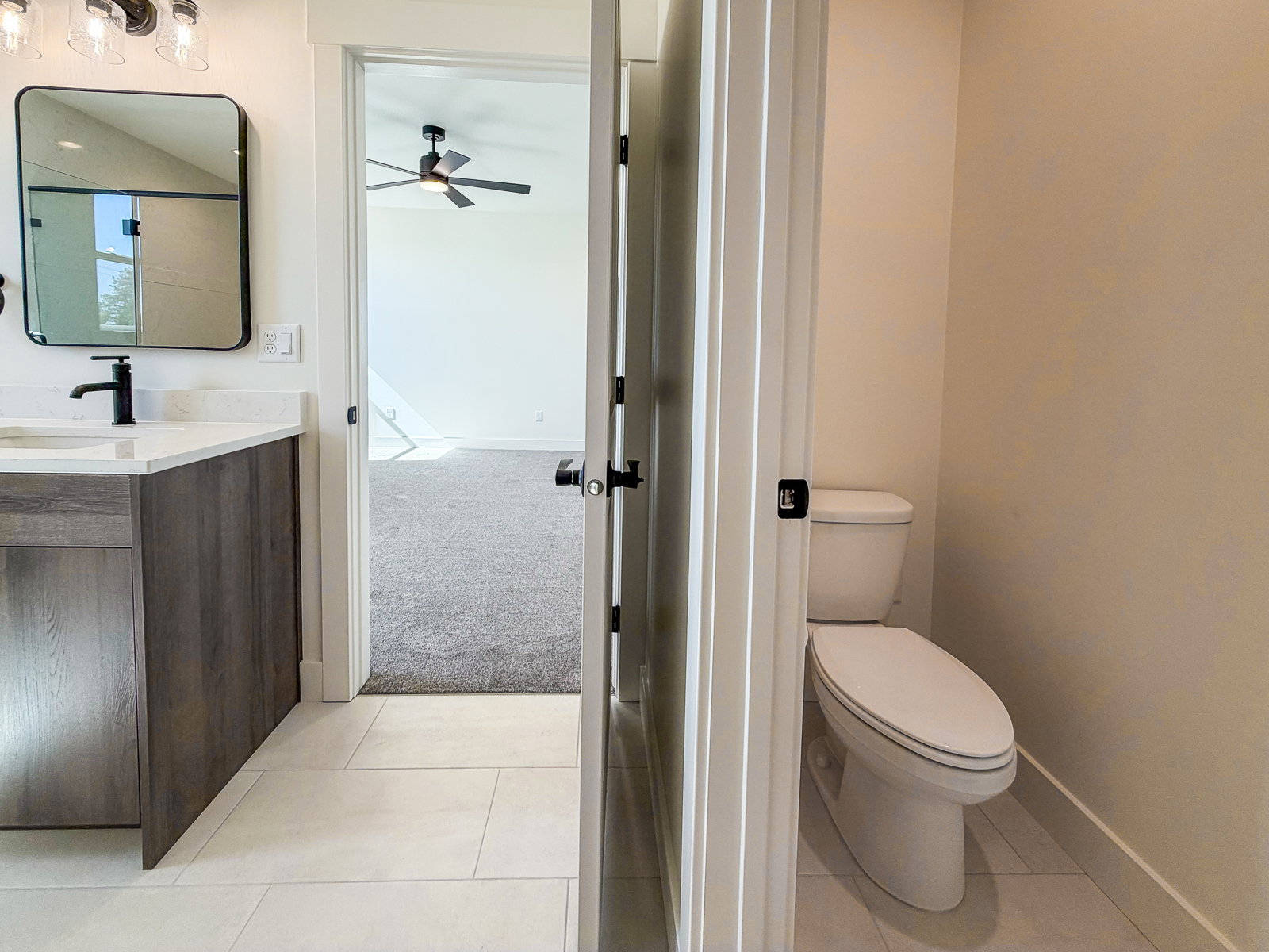 Bathroom featuring a modern vanity with a white countertop, matte black faucet, and rectangular framed mirror
