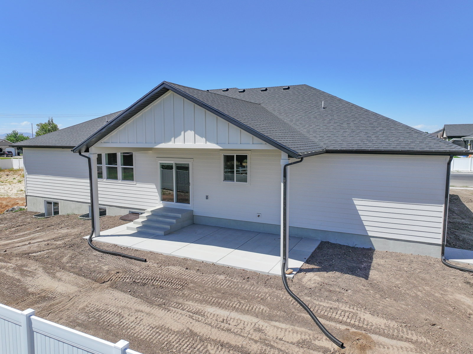 Contemporary exterior featuring white siding, a dark asphalt shingle roof, and board and batten accents