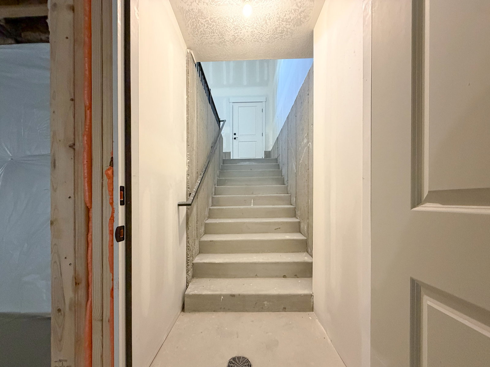 Concrete staircase with black metal handrail