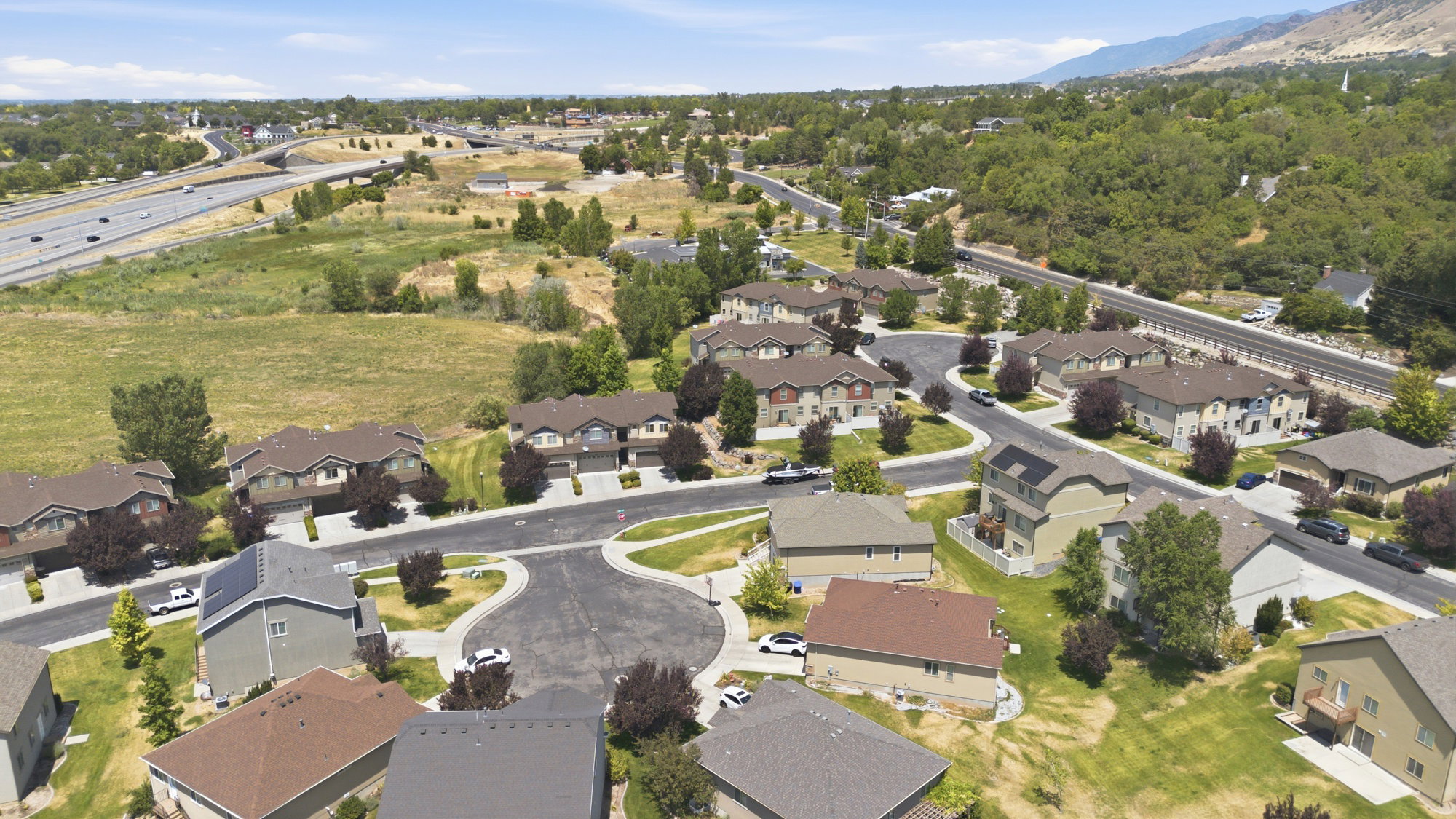 Residential community featuring multiple two-story homes and townhouses arranged along paved streets