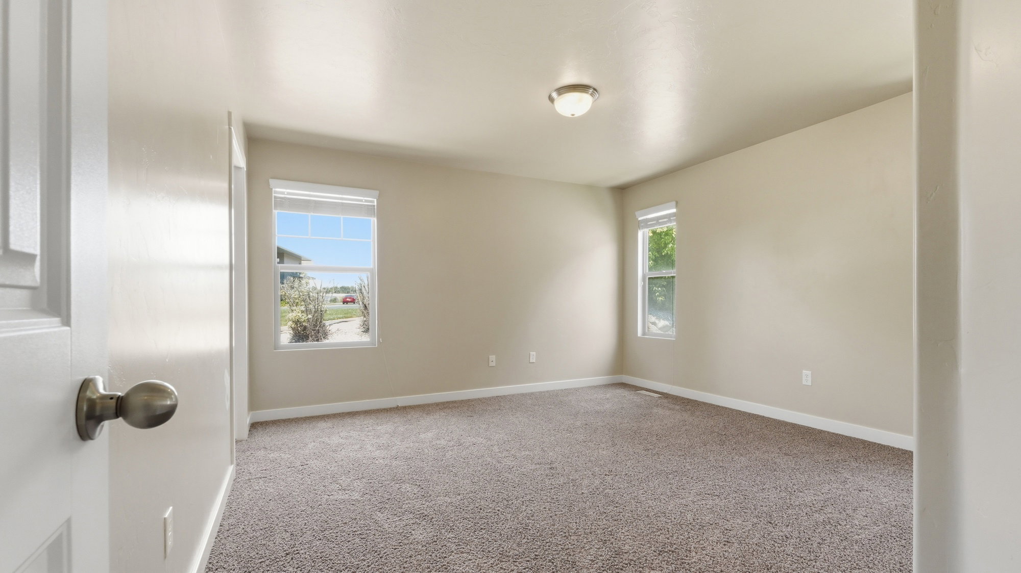Spacious room featuring neutral carpeting and light-toned walls
