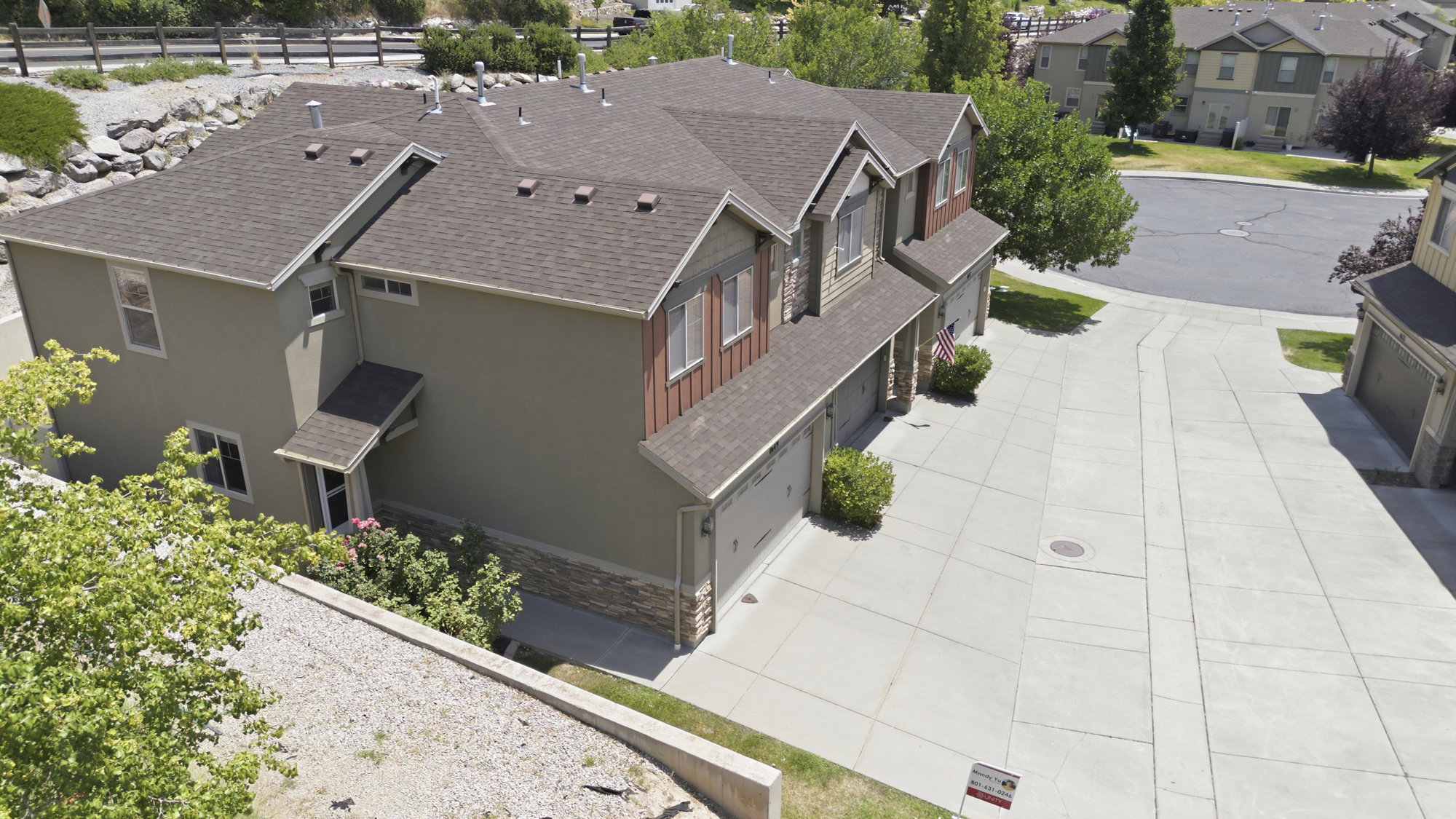 Multi-level residential structure featuring a shingled roof and a combination of stucco and wood-finish siding