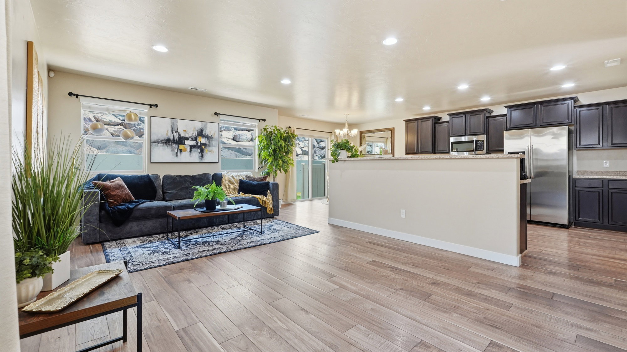 Open-concept living space featuring wood-finish flooring, recessed lighting, and a neutral color palette