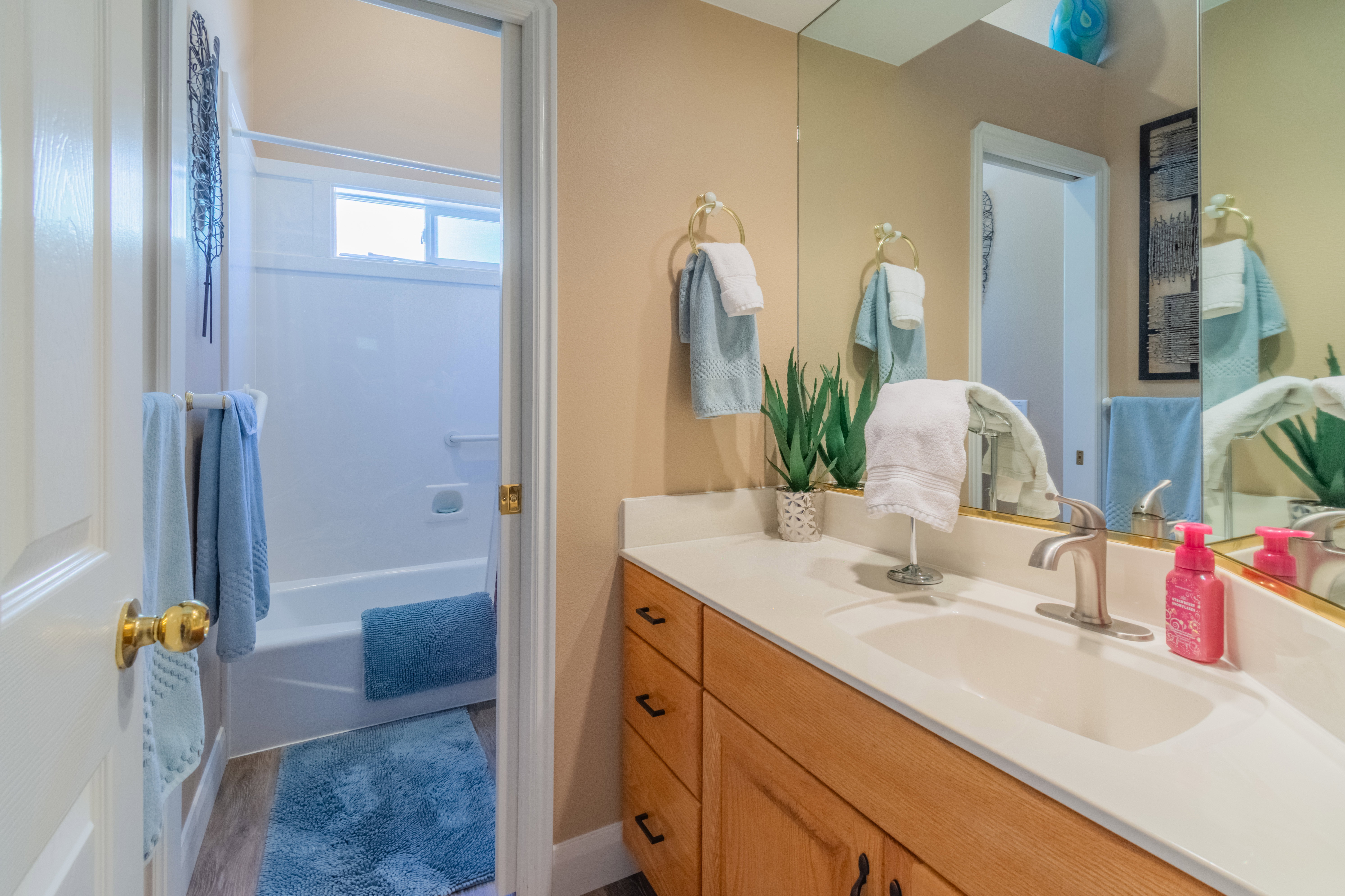 Bathroom vanity featuring a single basin sink, brushed nickel faucet, and a light-toned countertop