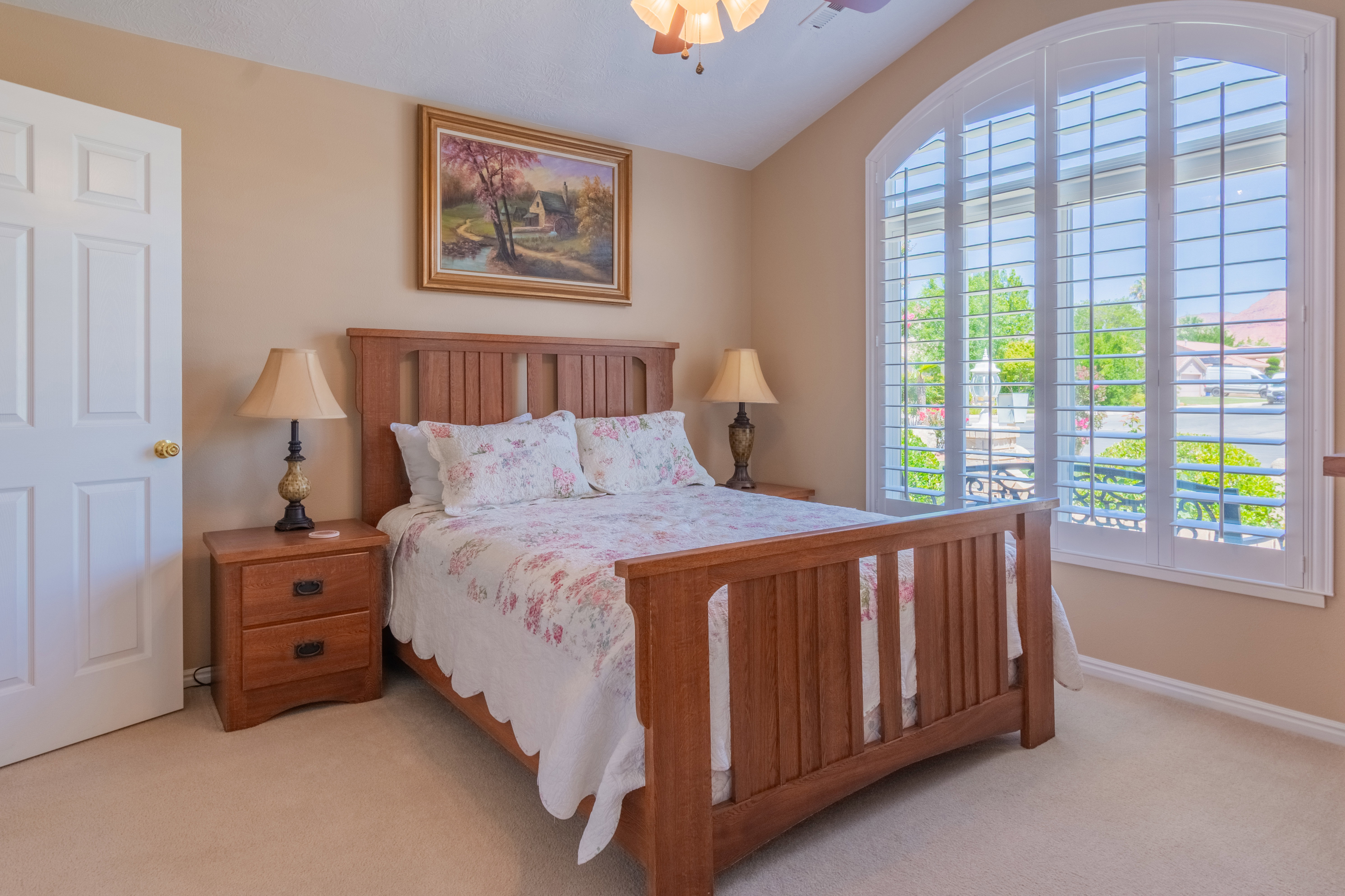 Arched window featuring plantation shutters