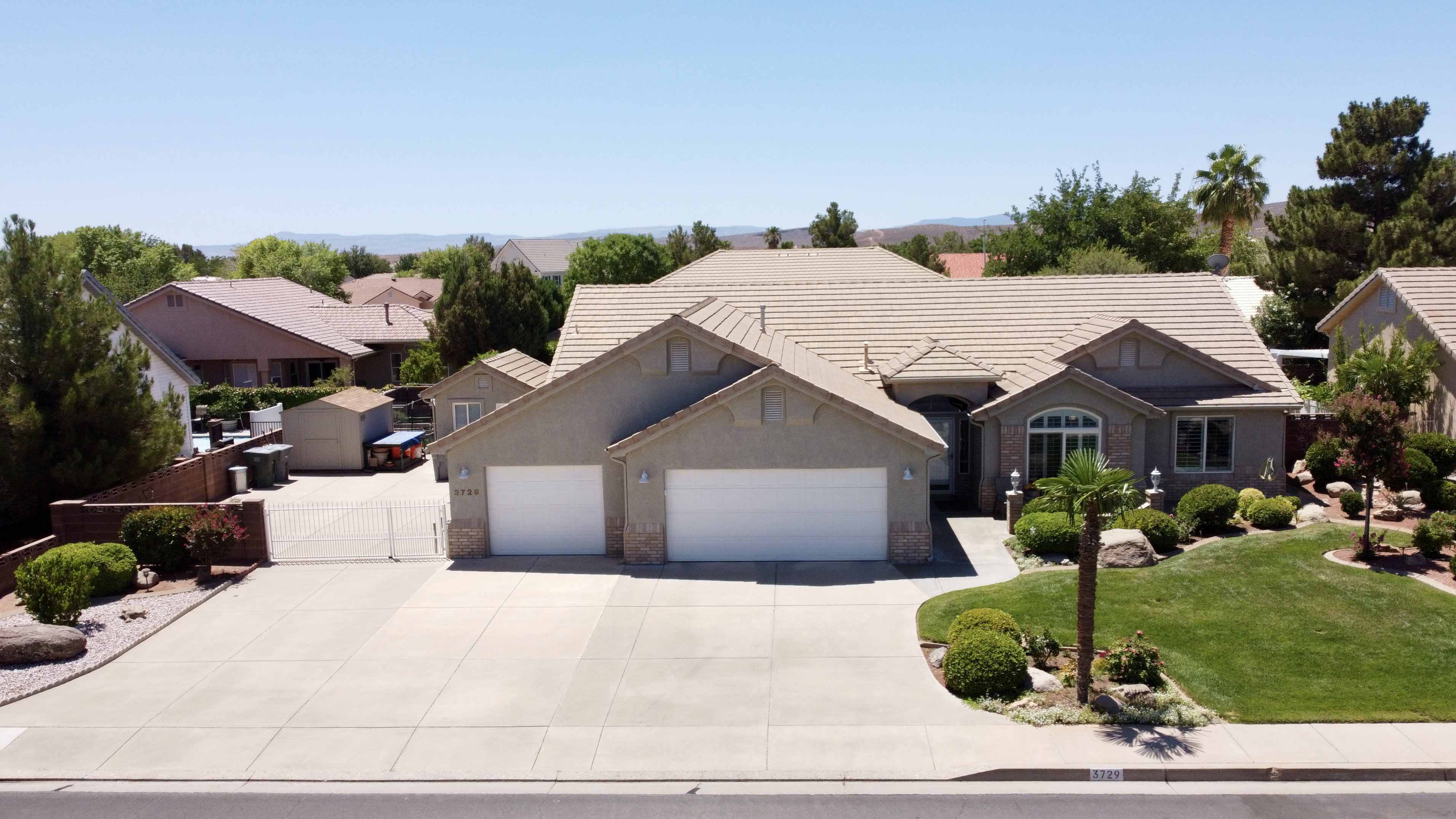 Stucco exterior residence featuring an attached double-door garage, concrete tile roofing, and arched windows