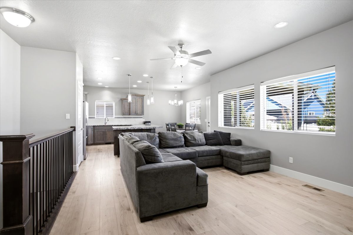 Open-concept living space featuring wood-finish flooring and ample natural light from multiple windows