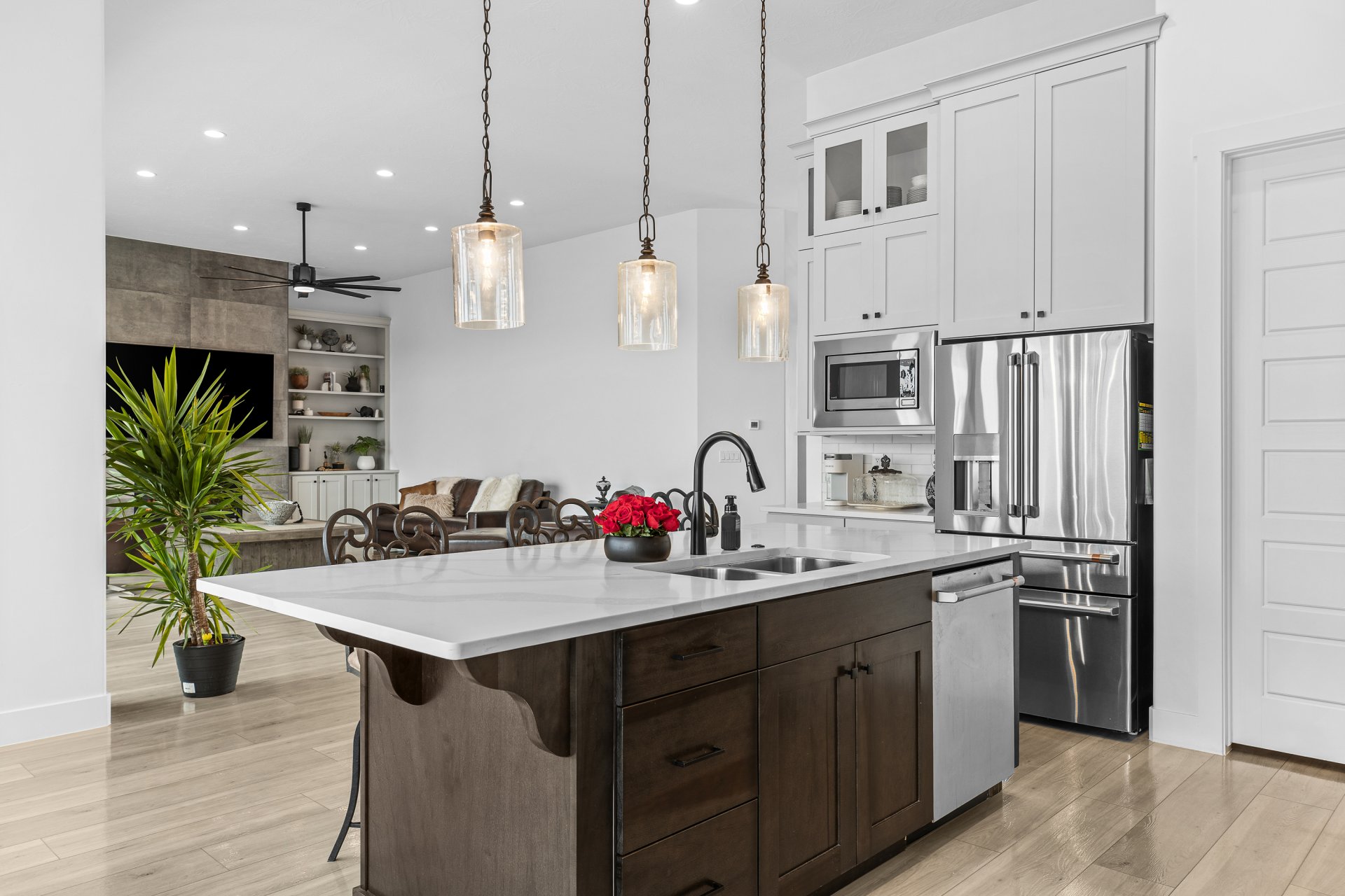 Spacious kitchen island featuring a dual basin sink and pendant lighting