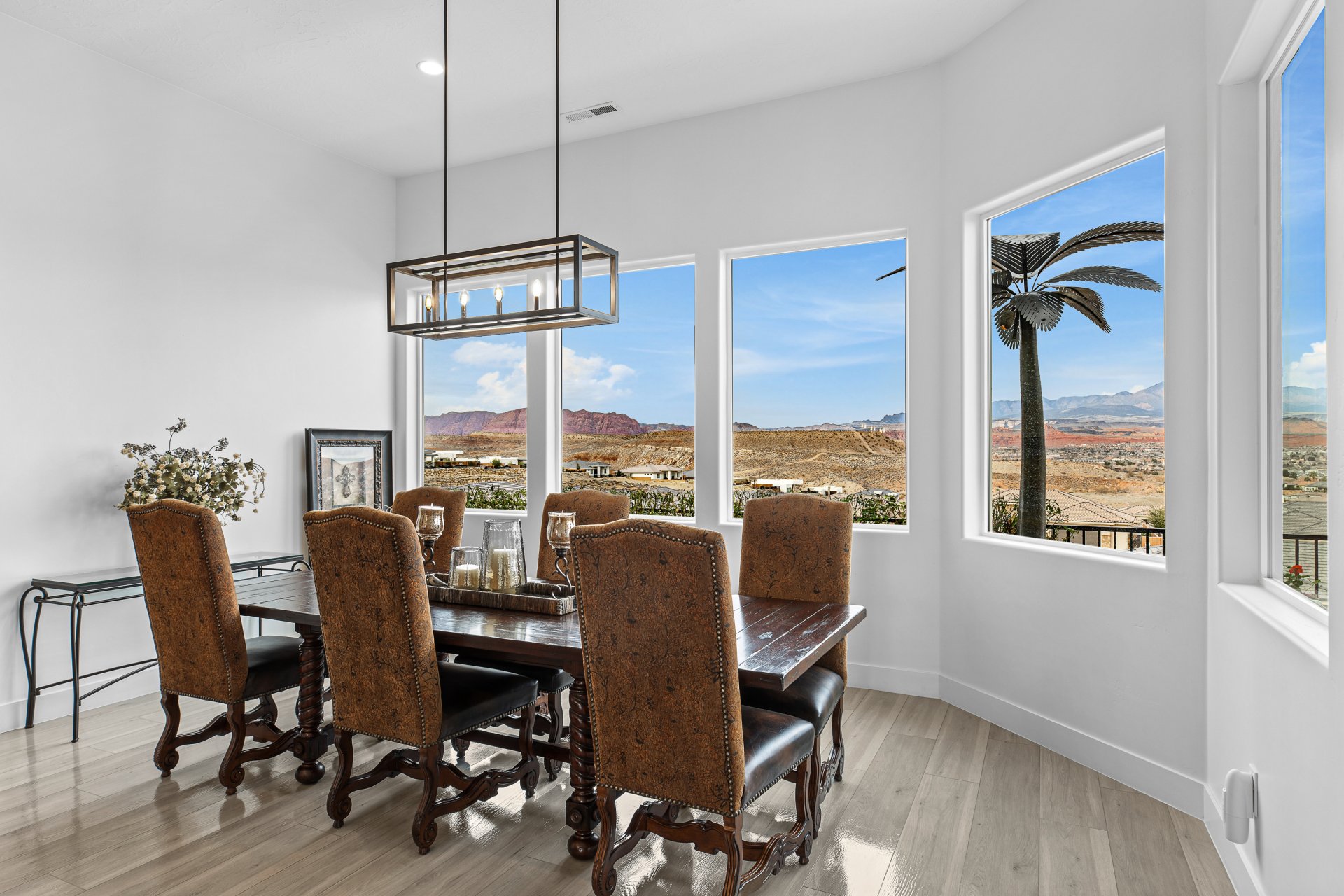 Dining space featuring light wood-finish flooring and multiple windows framing a desert landscape
