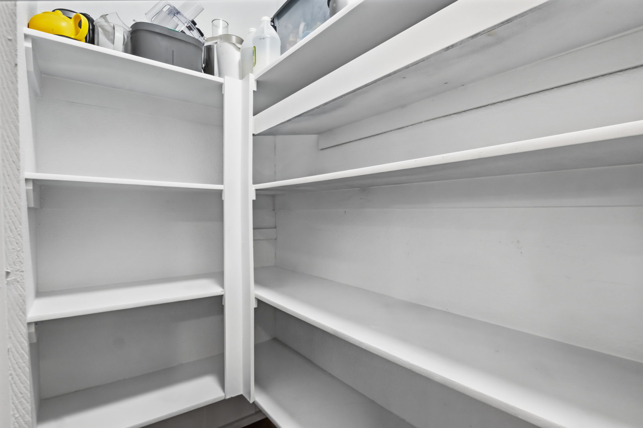 Spacious pantry featuring multiple tiers of white shelving