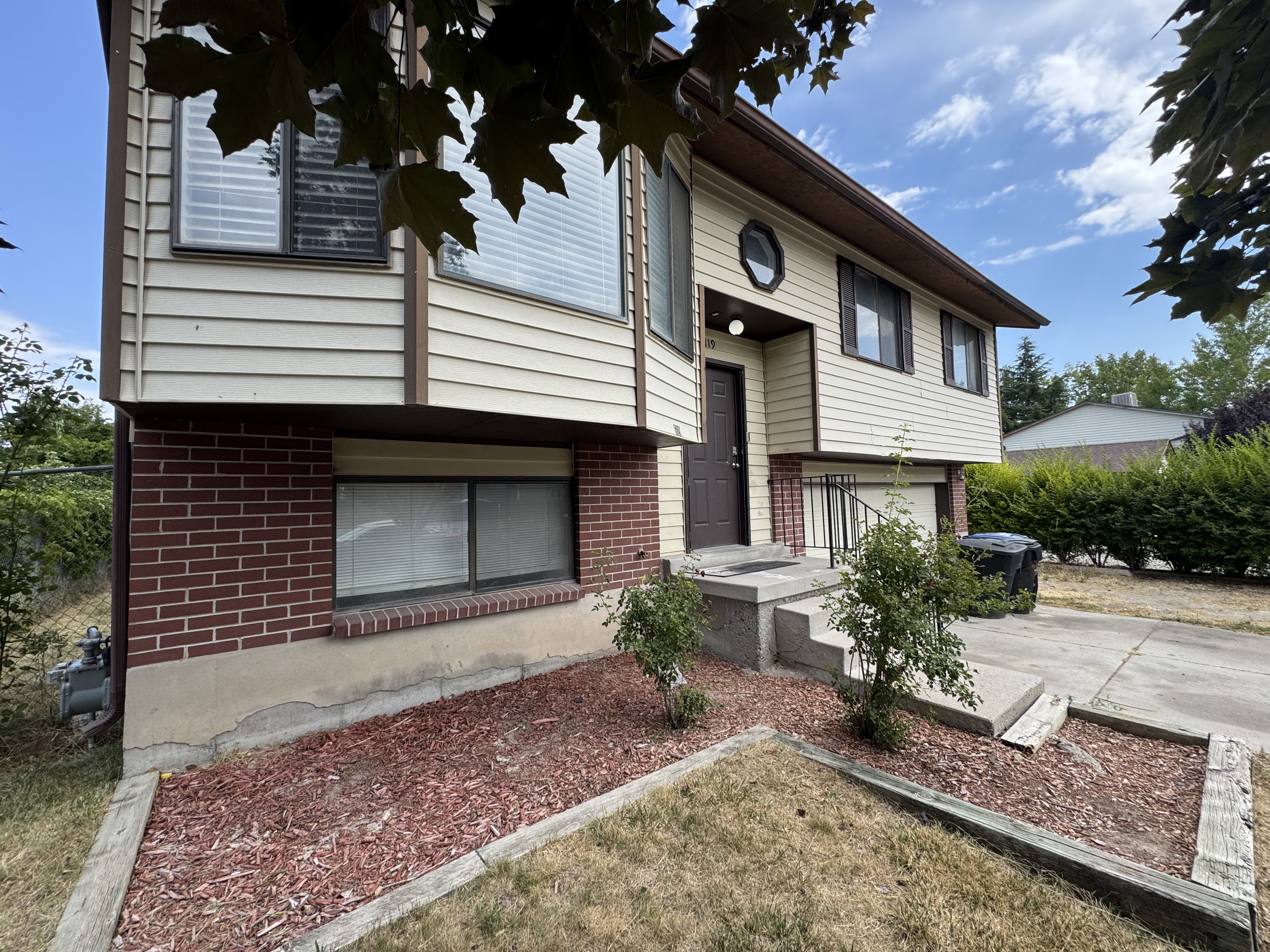 Split-level residence featuring a brick and siding exterior
