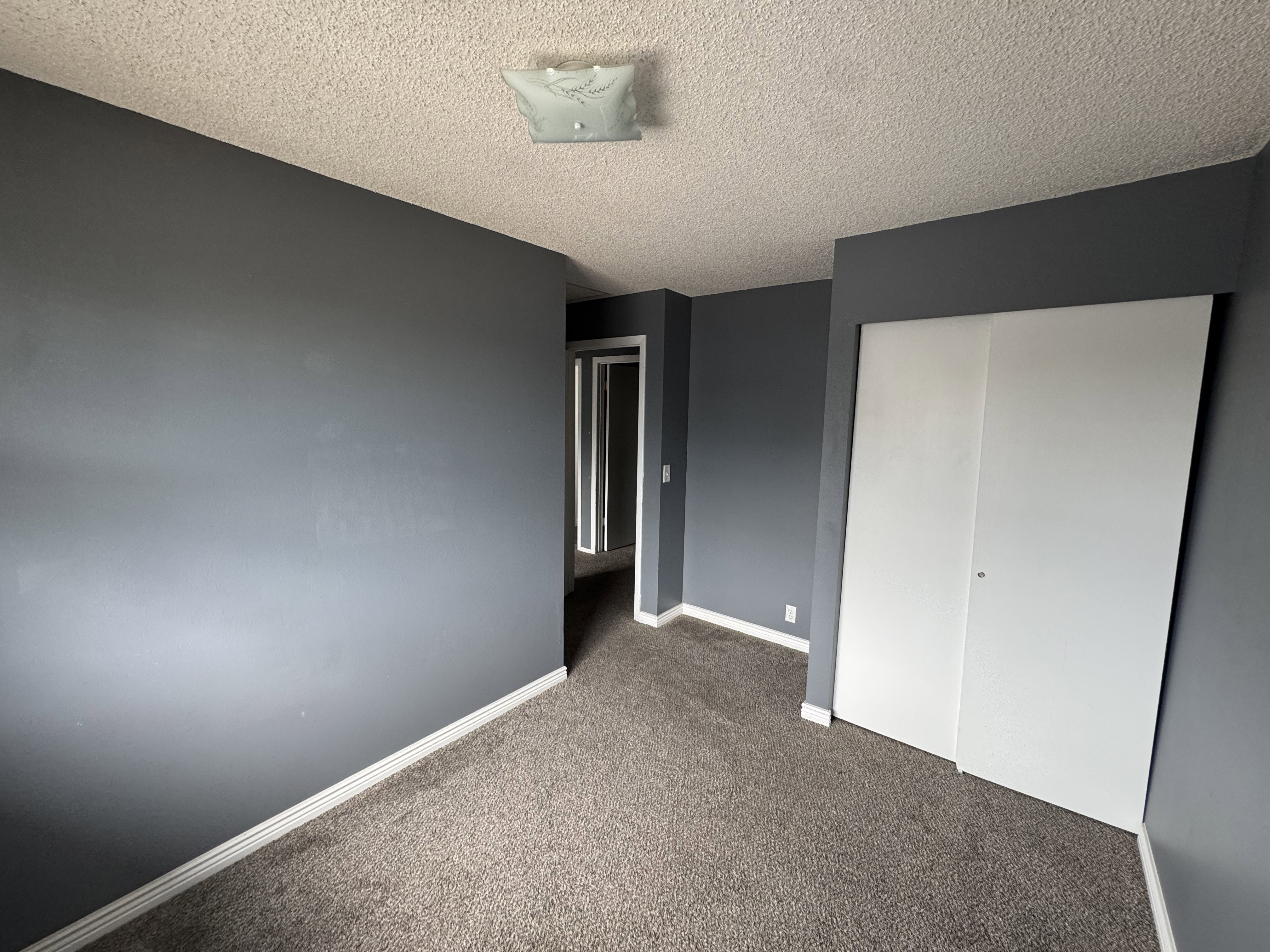 Bedroom featuring grey carpet flooring and white baseboards