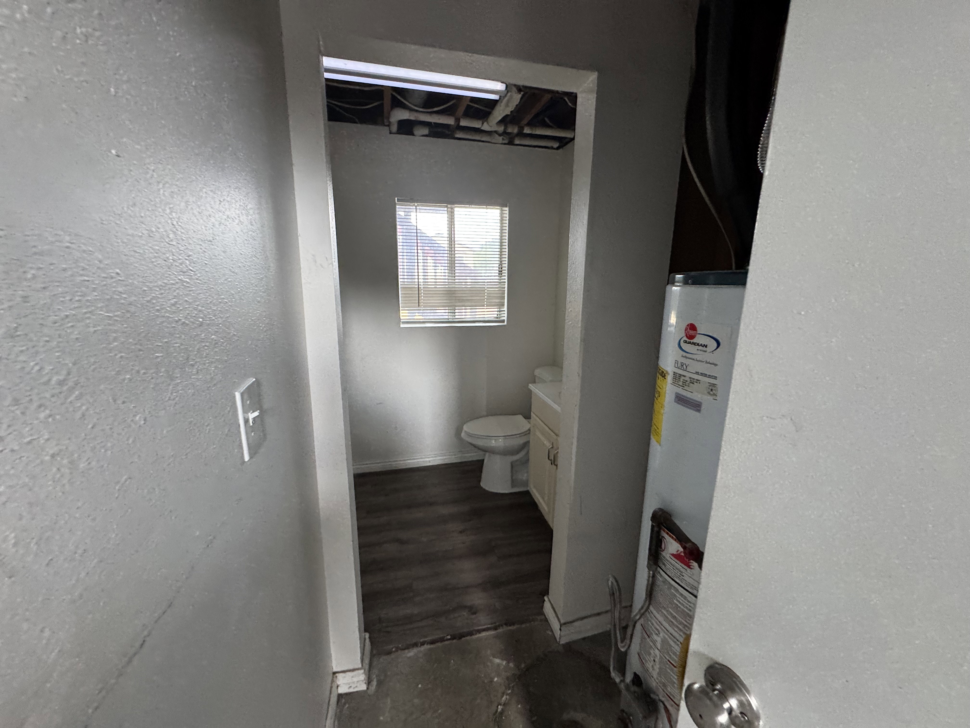 Compact utility room featuring a built-in water heater