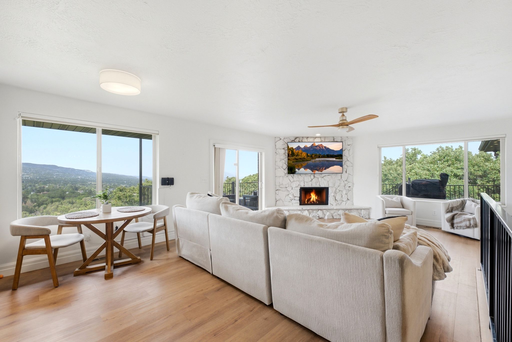 Living area featuring light wood-finish flooring and multiple large windows