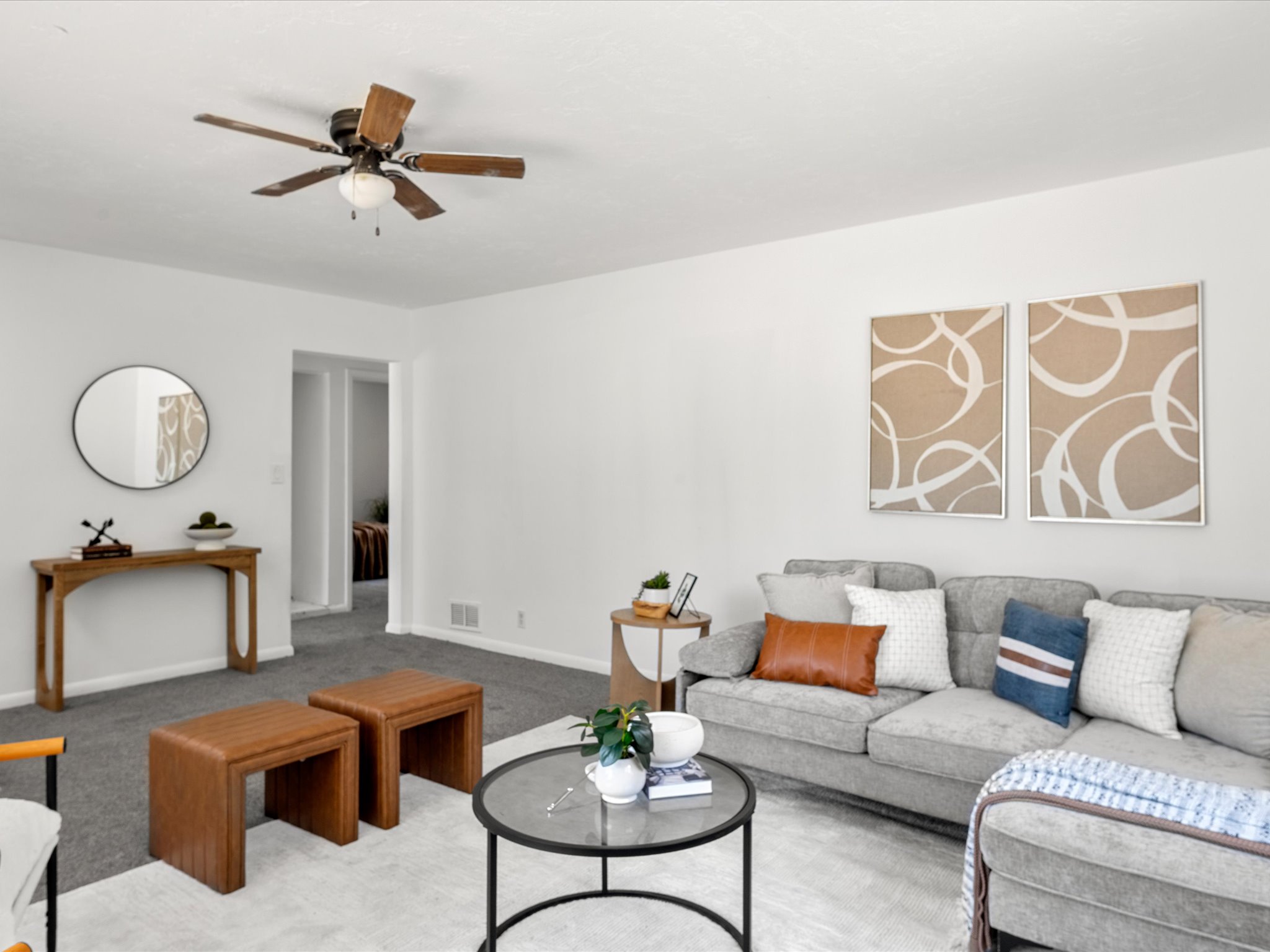Bright living area featuring light gray carpet flooring and white walls