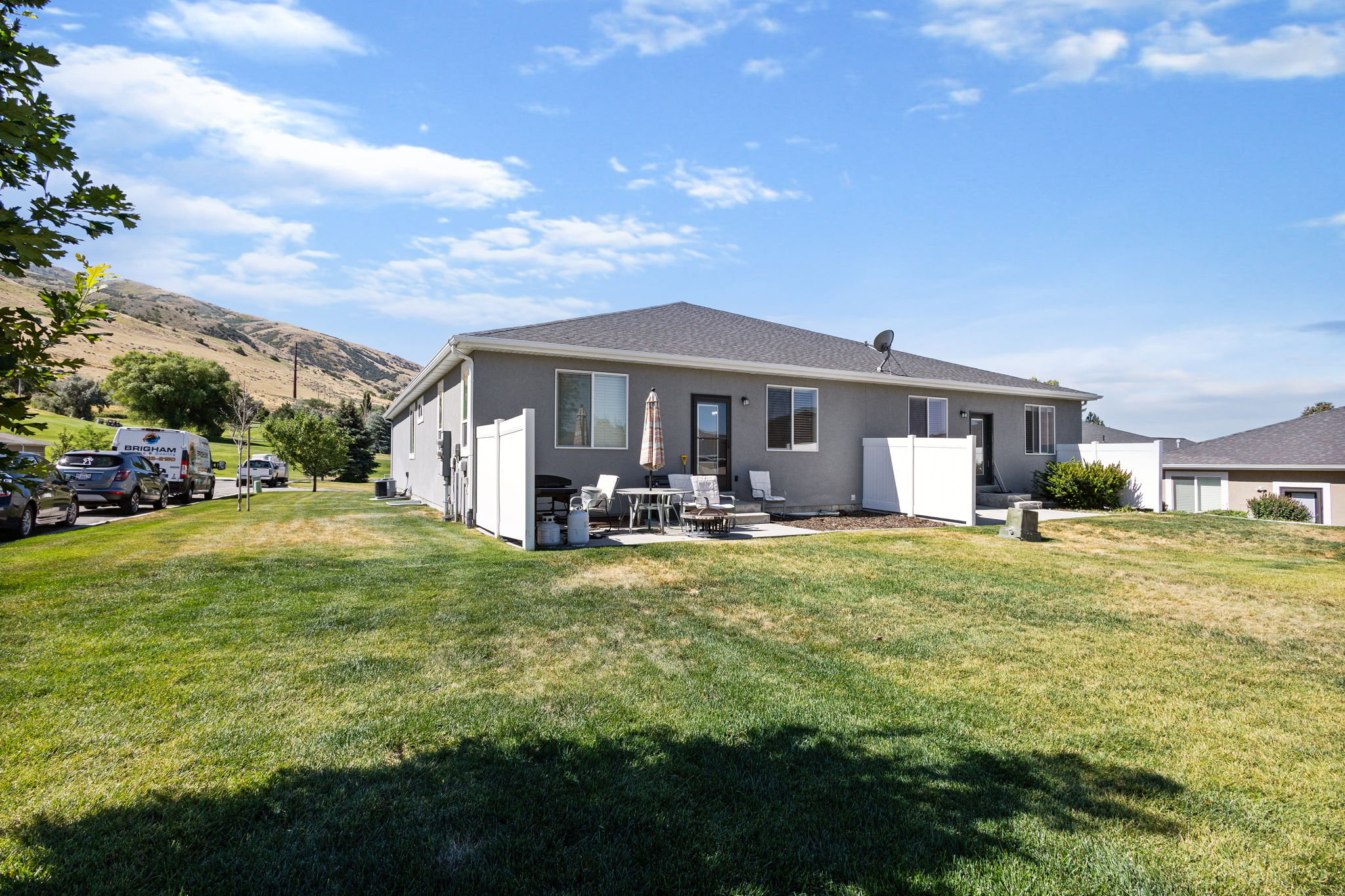 Rear exterior featuring a gray stucco finish and a dark shingle roof