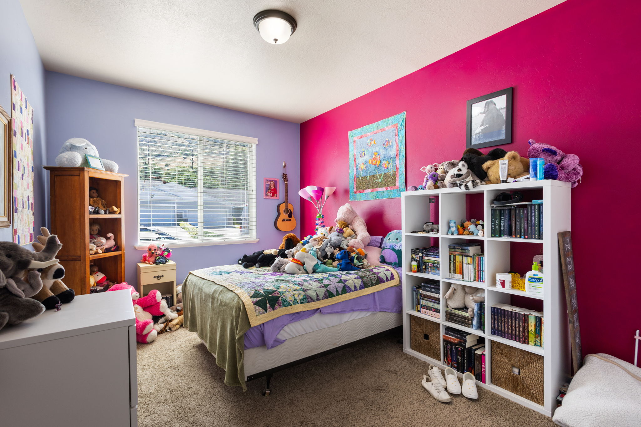 Carpeted room with a ceiling-mounted light fixture, featuring a window with horizontal blinds and two-tone wall finishes