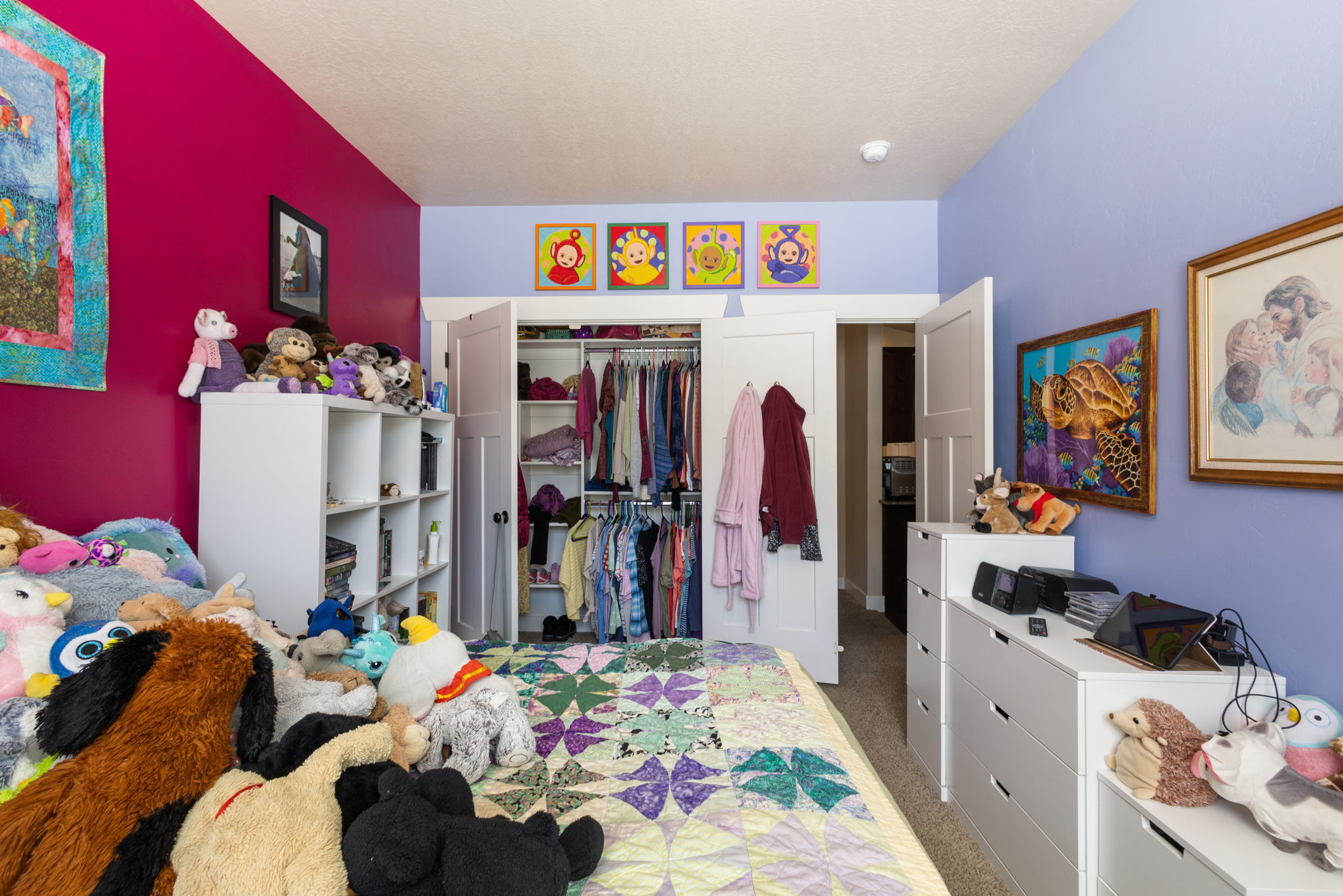 Built-in closet with double doors, wood-finish flooring, and white trim