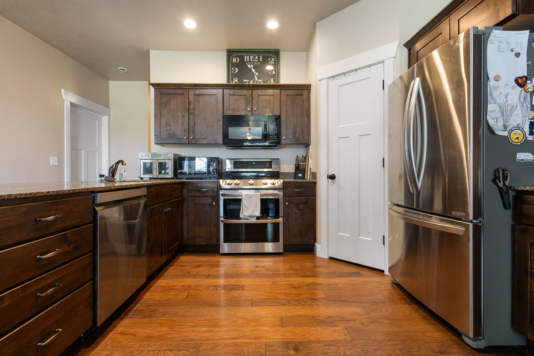 Kitchen featuring wood-finish flooring, dark wood cabinetry, and stainless steel appliances
