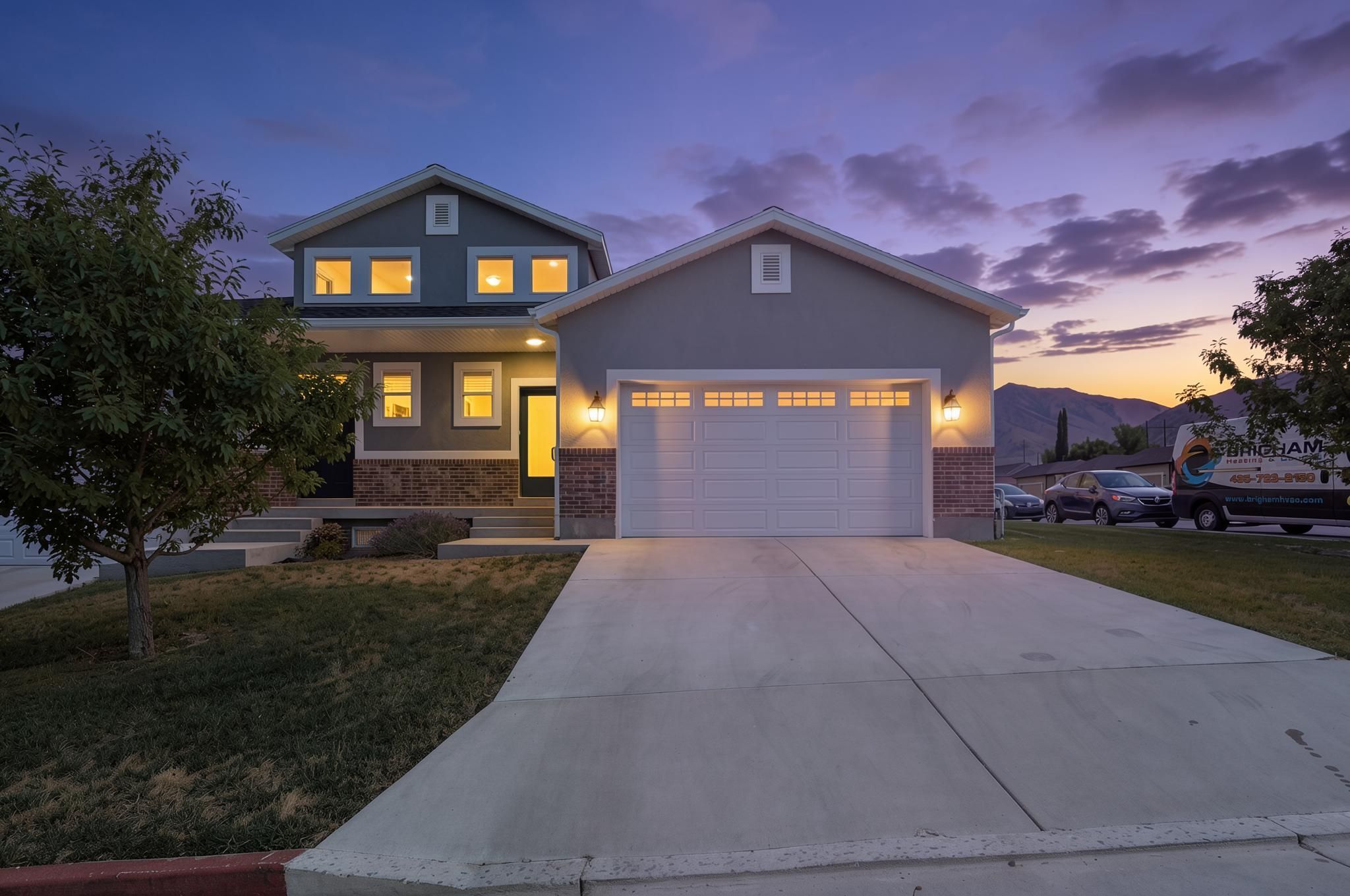 Two-story residence featuring a dual-tone facade with stone and stucco finishes