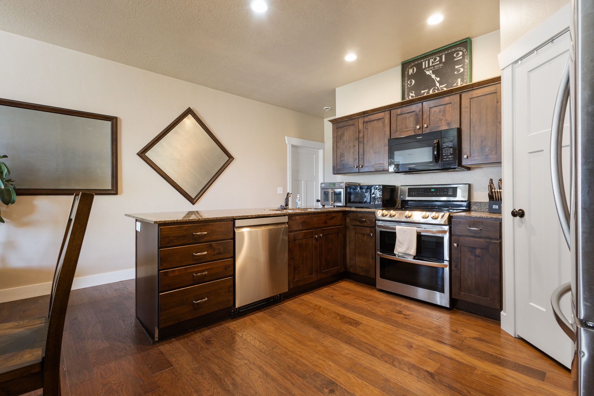 Kitchen featuring wood-finish flooring, dark wood cabinetry, and recessed lighting