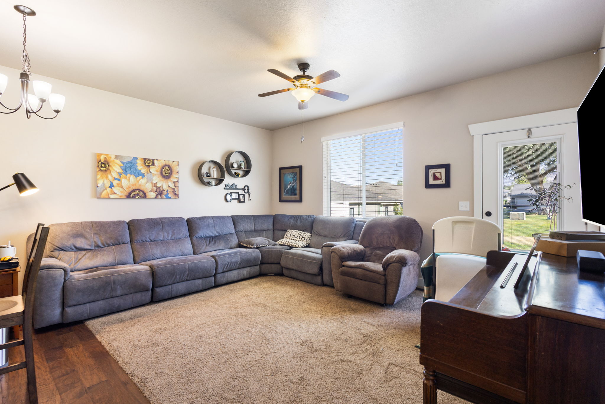 Bright living space featuring a combination of carpet and wood-finish flooring