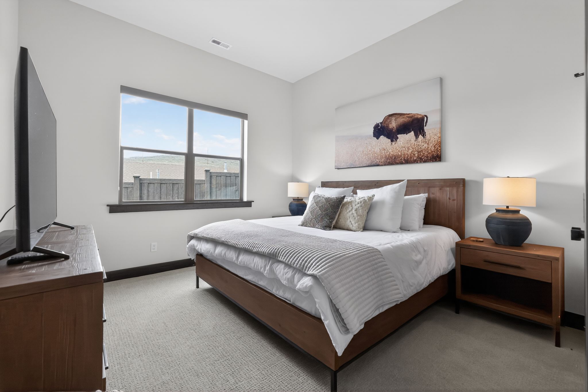 Carpeted bedroom featuring a large window with mountain scenery
