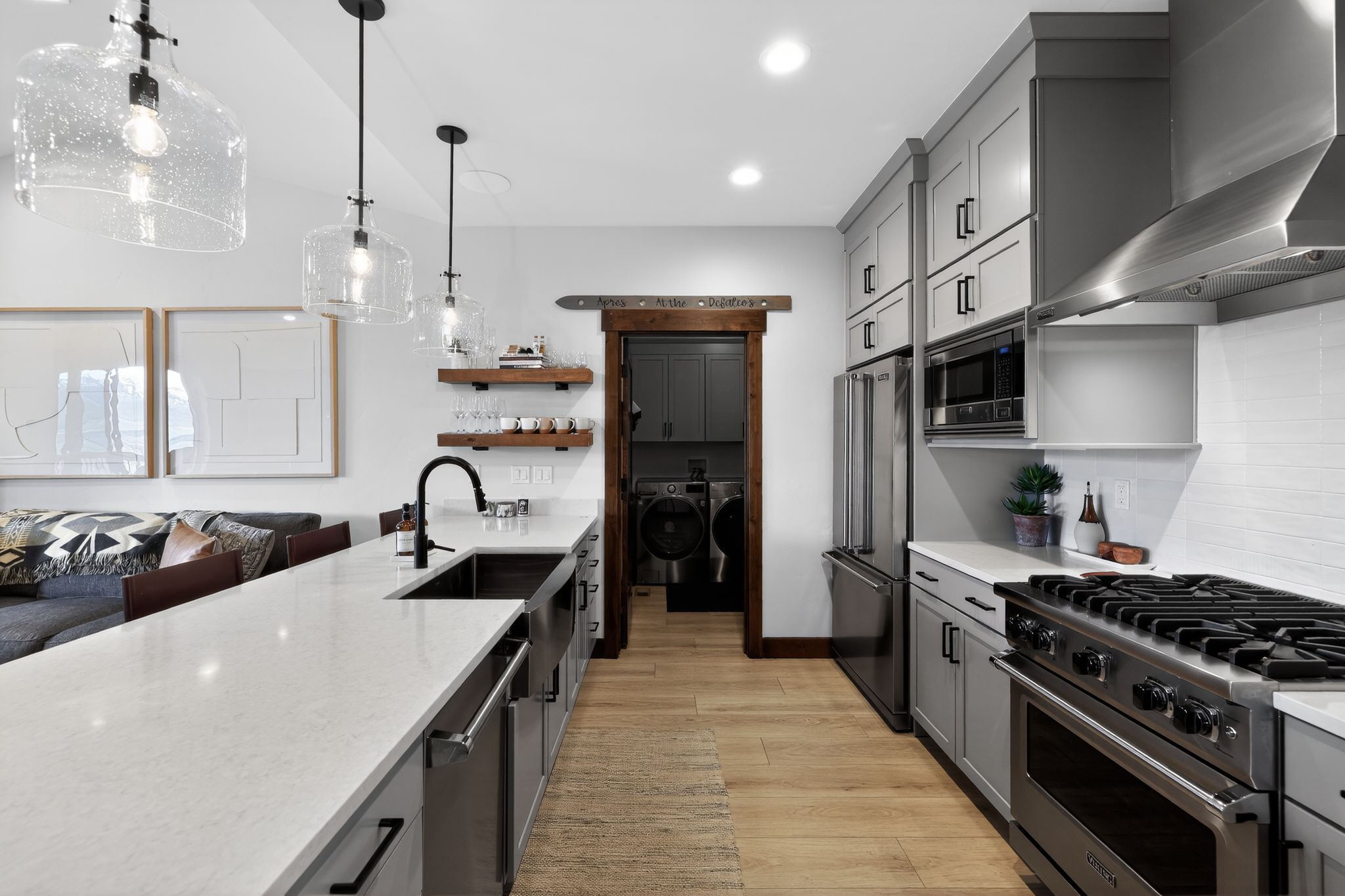 Modern kitchen featuring light wood-finish flooring and a spacious island with a built-in sink