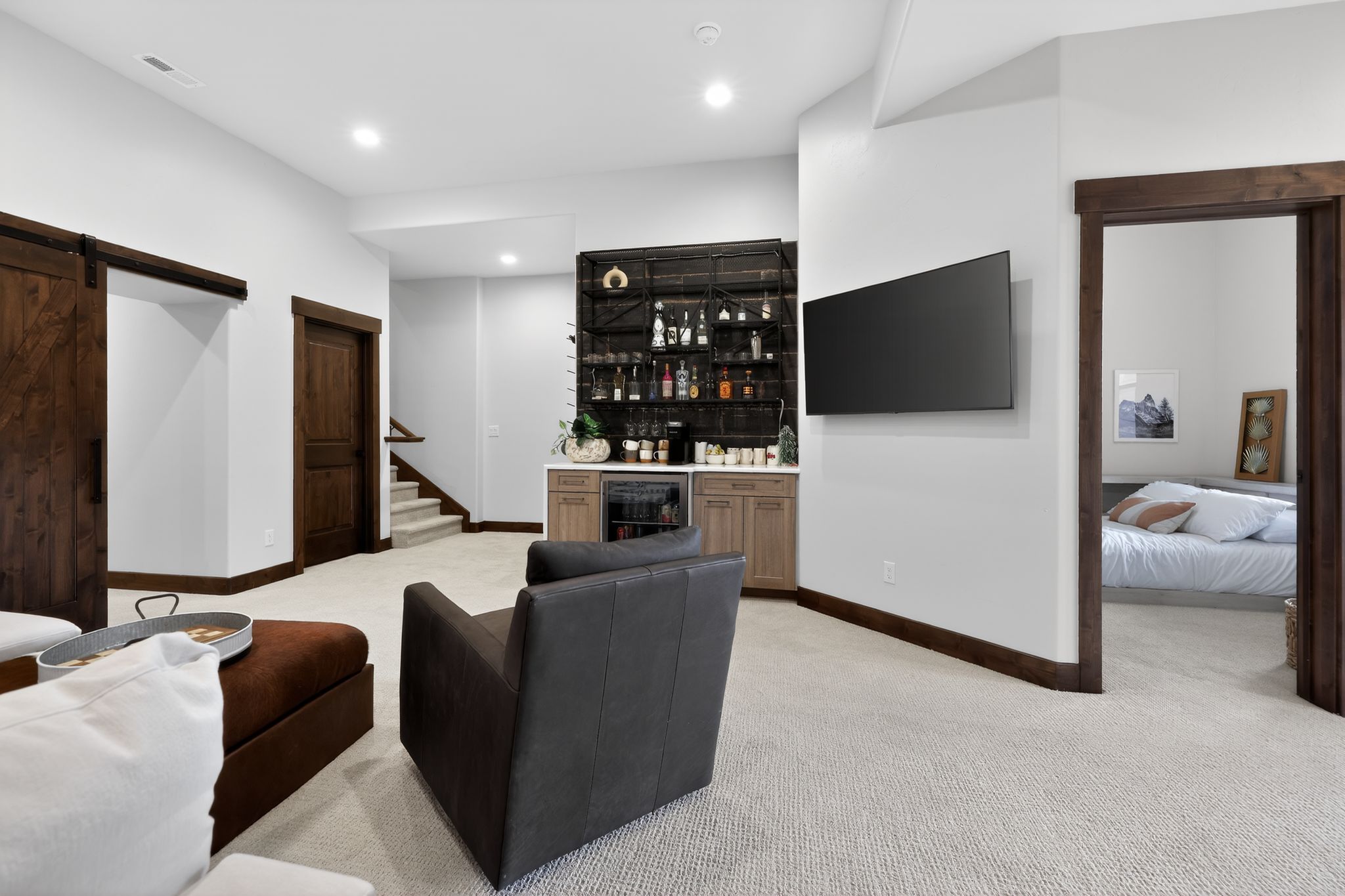 Finished basement with a built-in wet bar featuring shelving, cabinetry, and a beverage cooler