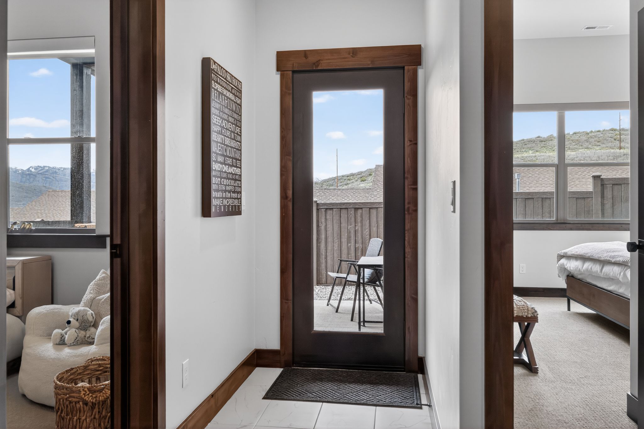 Full-light exterior door with dark wood trim opening to an outdoor patio area