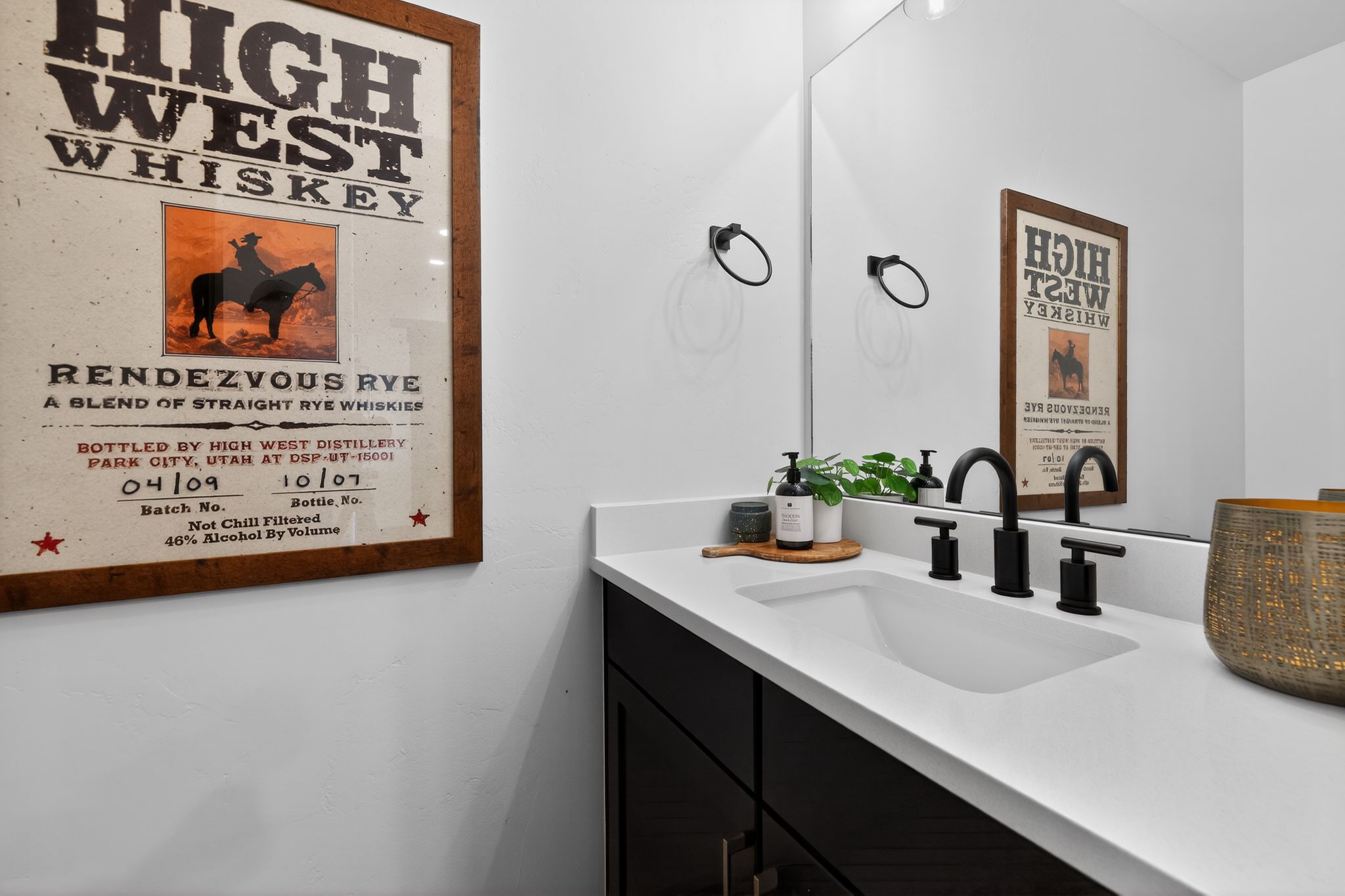 Vanity featuring a white integrated sink, matte black faucet, and a large wall-mounted mirror