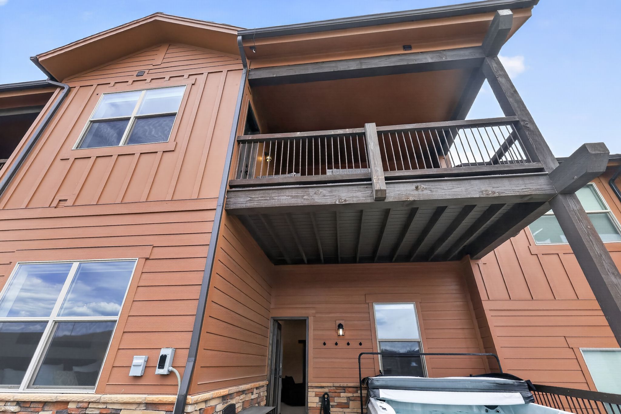 Multi-level exterior featuring horizontal siding, board and batten accents, and a stone veneer foundation