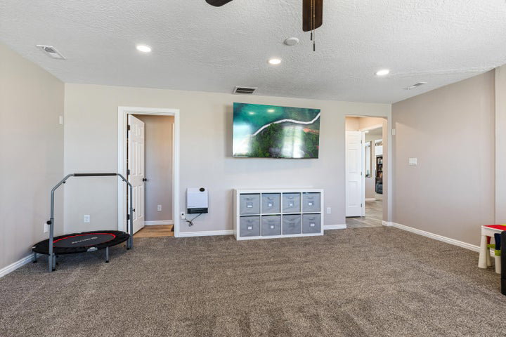 Spacious room featuring neutral carpeting, recessed lighting, and a ceiling fan
