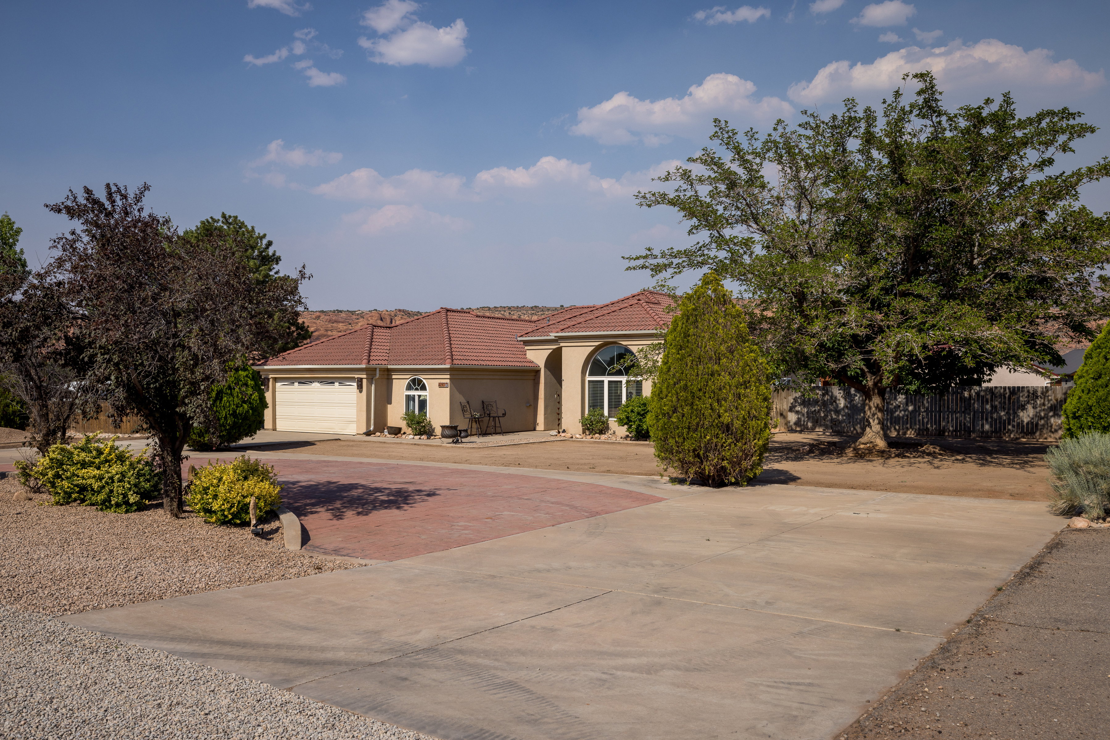 Stucco exterior residence with a terracotta tile roof and an attached two-car garage