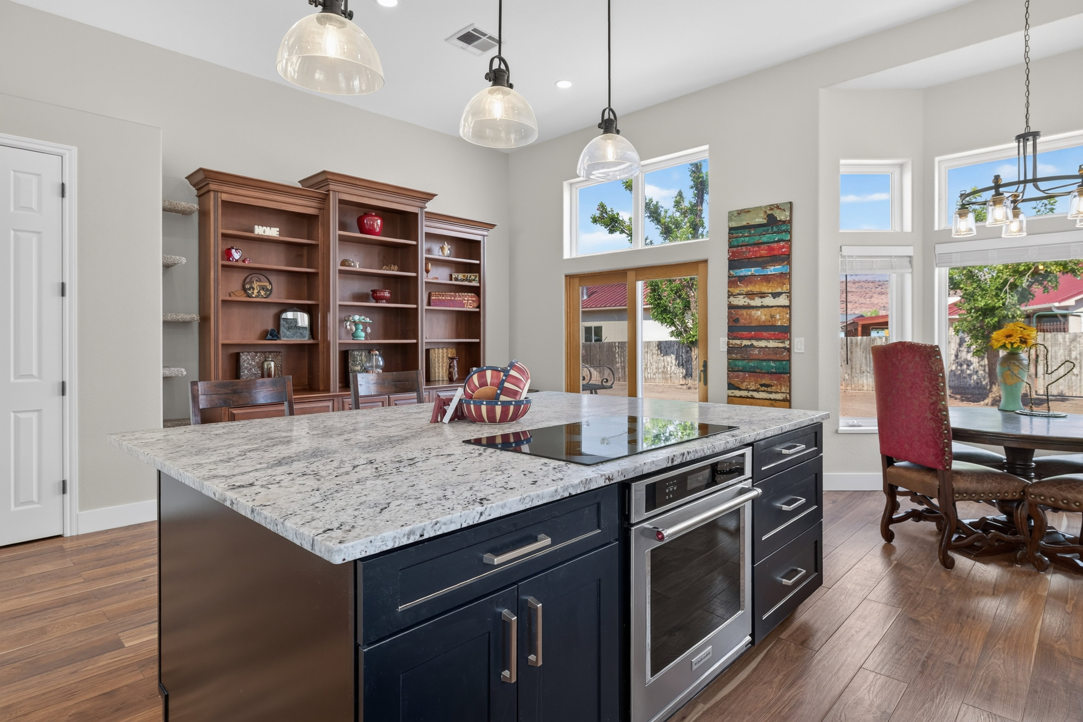 Kitchen island with a built-in cooktop and oven, featuring a light-colored speckled countertop