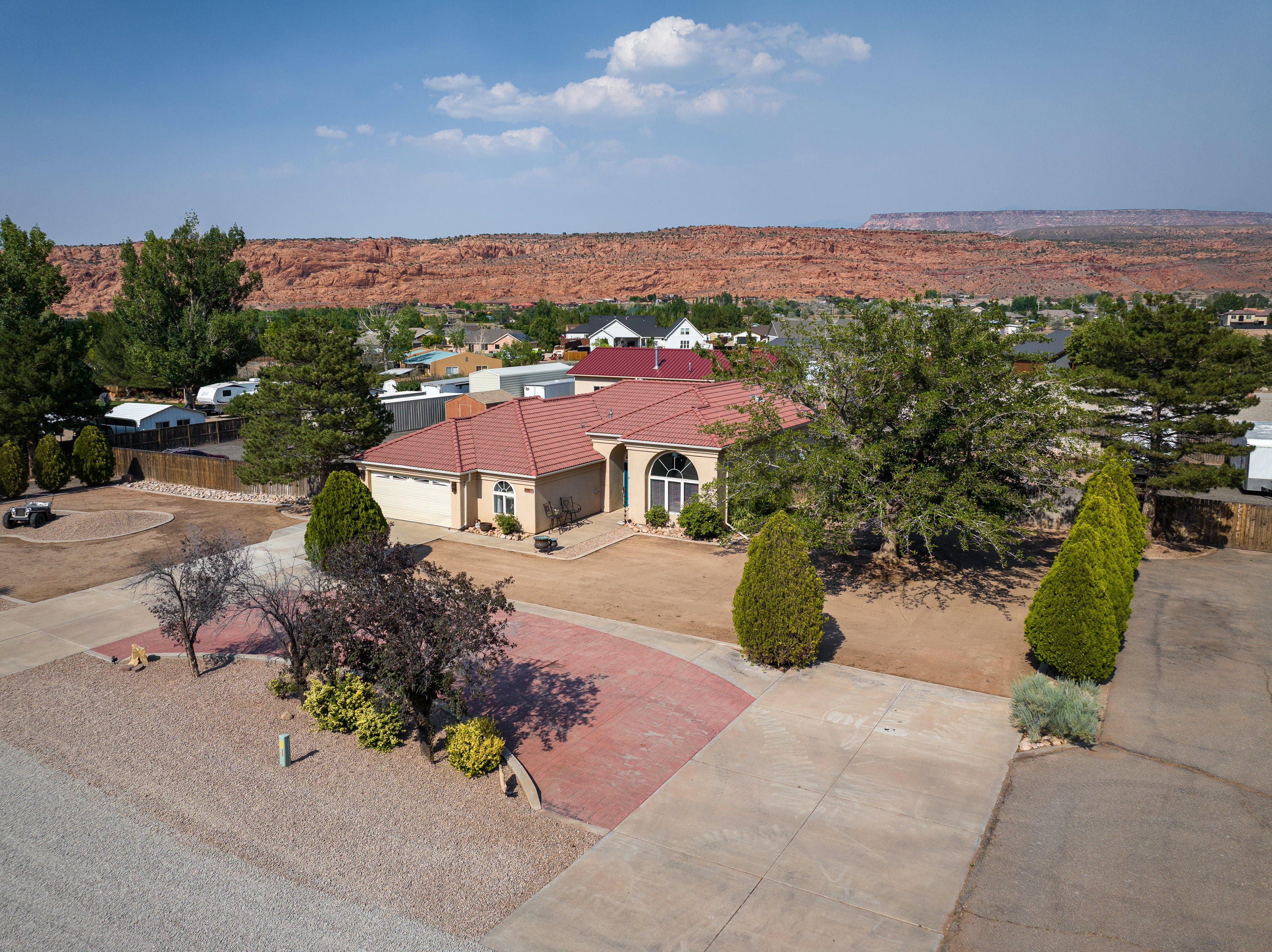 Single-story residence featuring a terracotta-hued tile roof and a tan stucco exterior