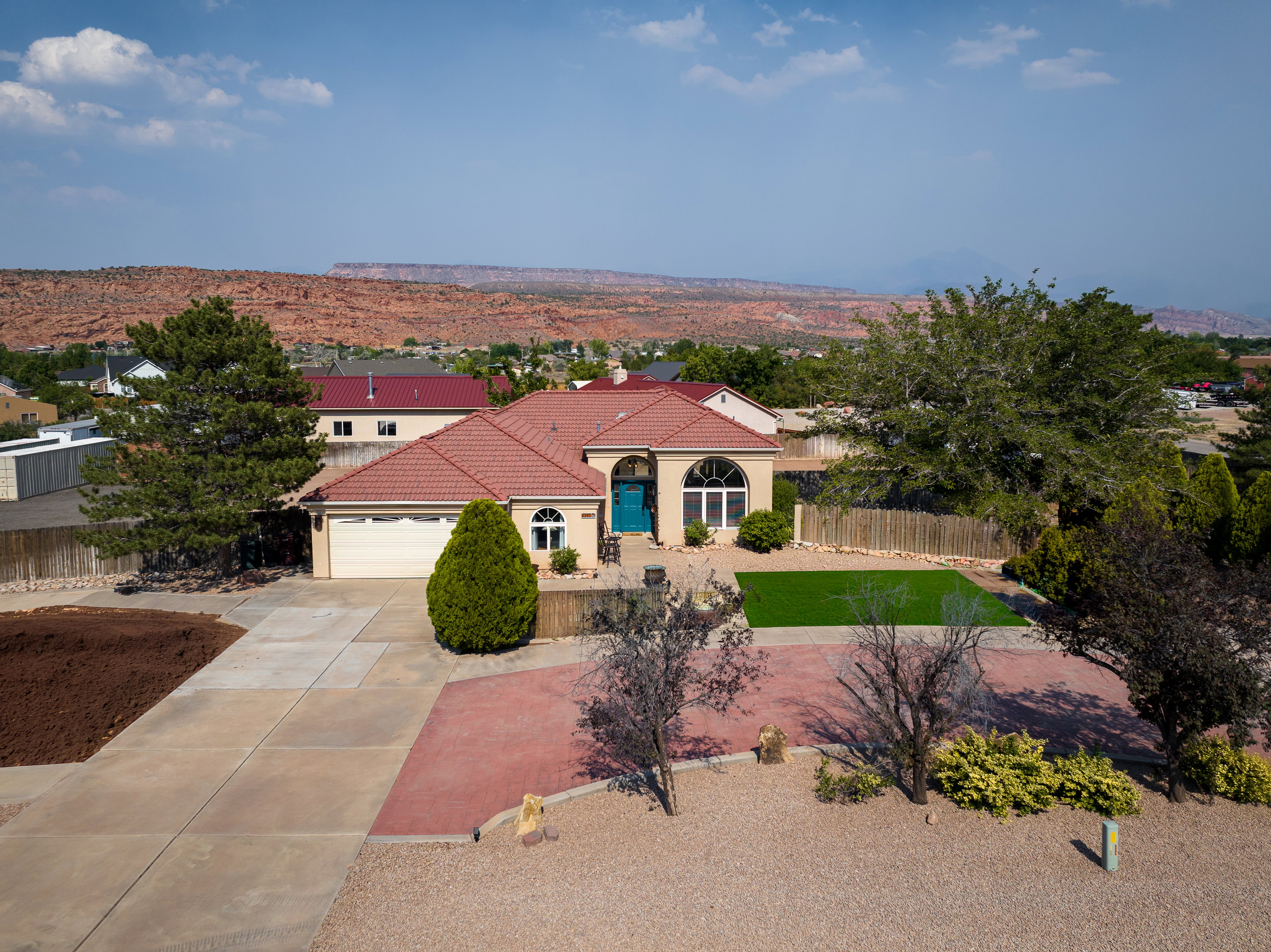Single-story residence featuring a tile roof, arched windows, and a vibrant turquoise front door