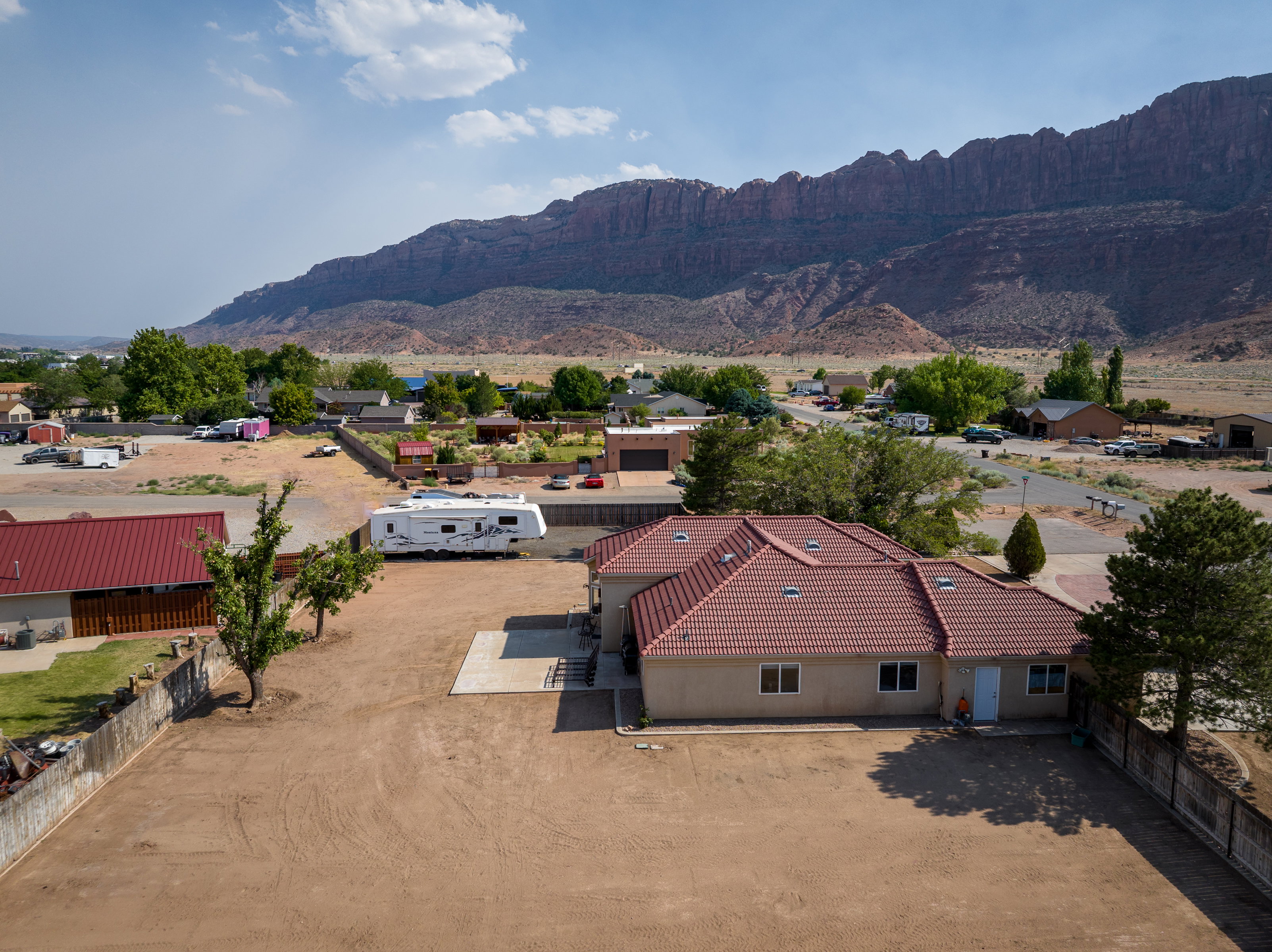 Single-story residence featuring a terracotta-hued tile roof and a neutral-toned stucco exterior