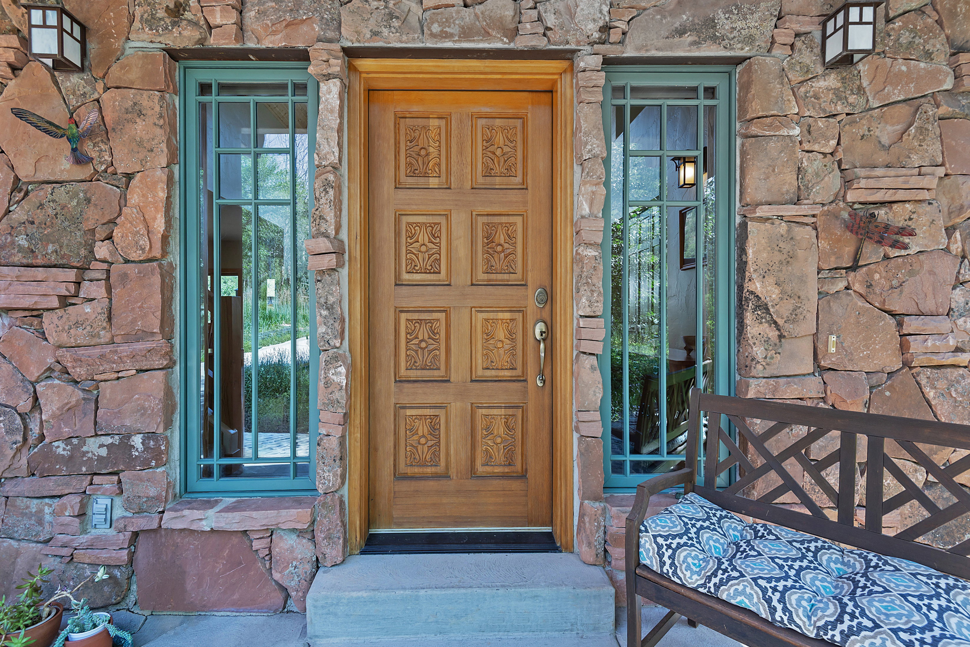 Stone veneer exterior featuring an ornate wood-paneled entry door
