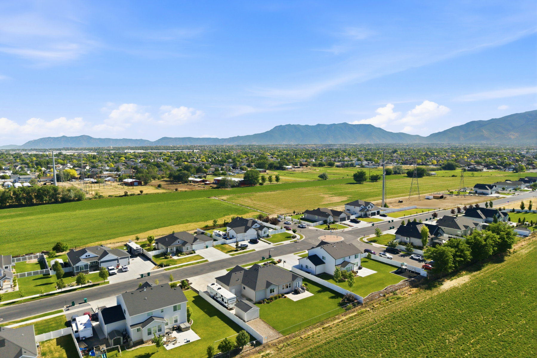 Aerial perspective showcasing a residential development with single-family homes and mountain scenery
