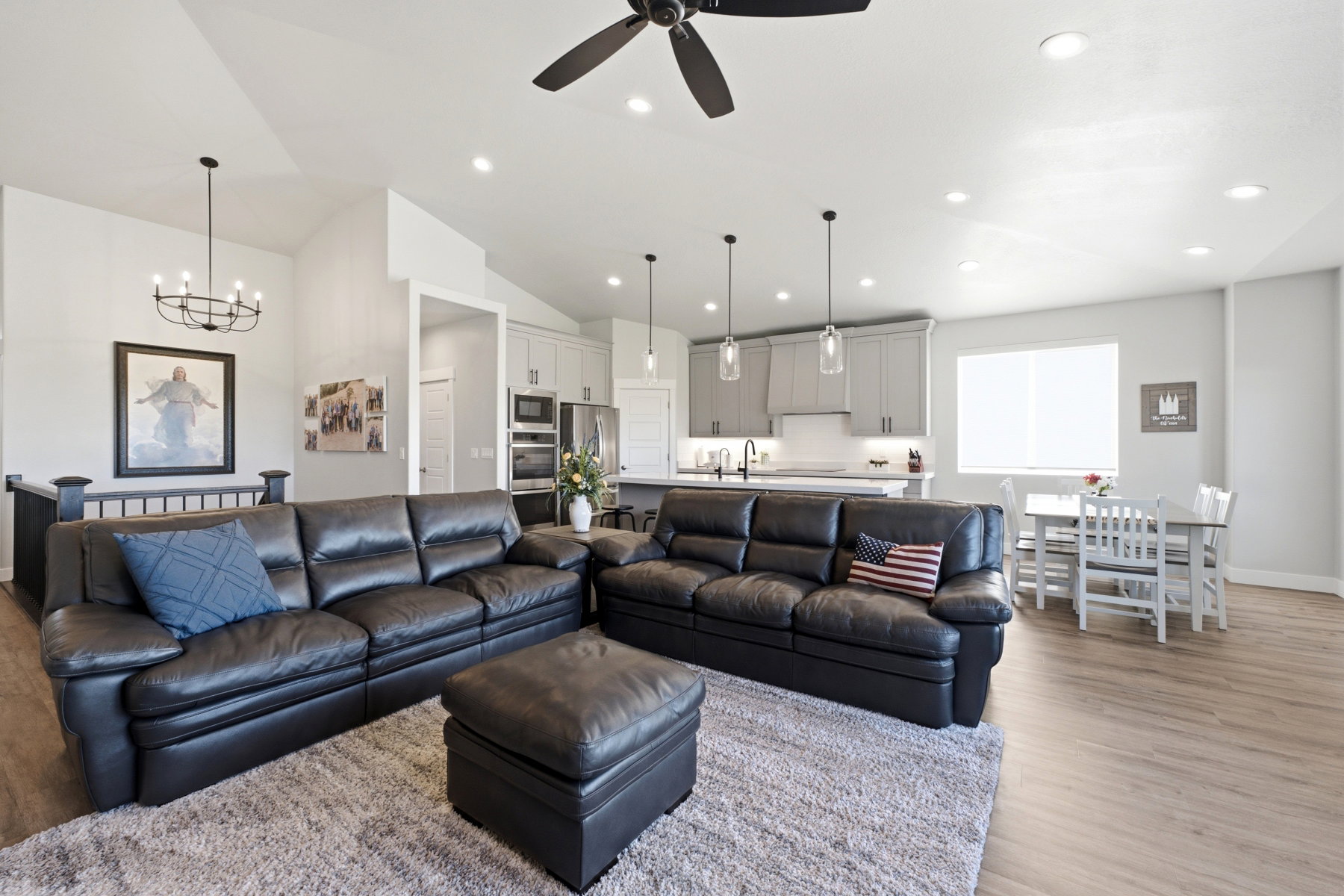 Open-concept living space featuring wood-finish flooring, recessed lighting, and a vaulted ceiling