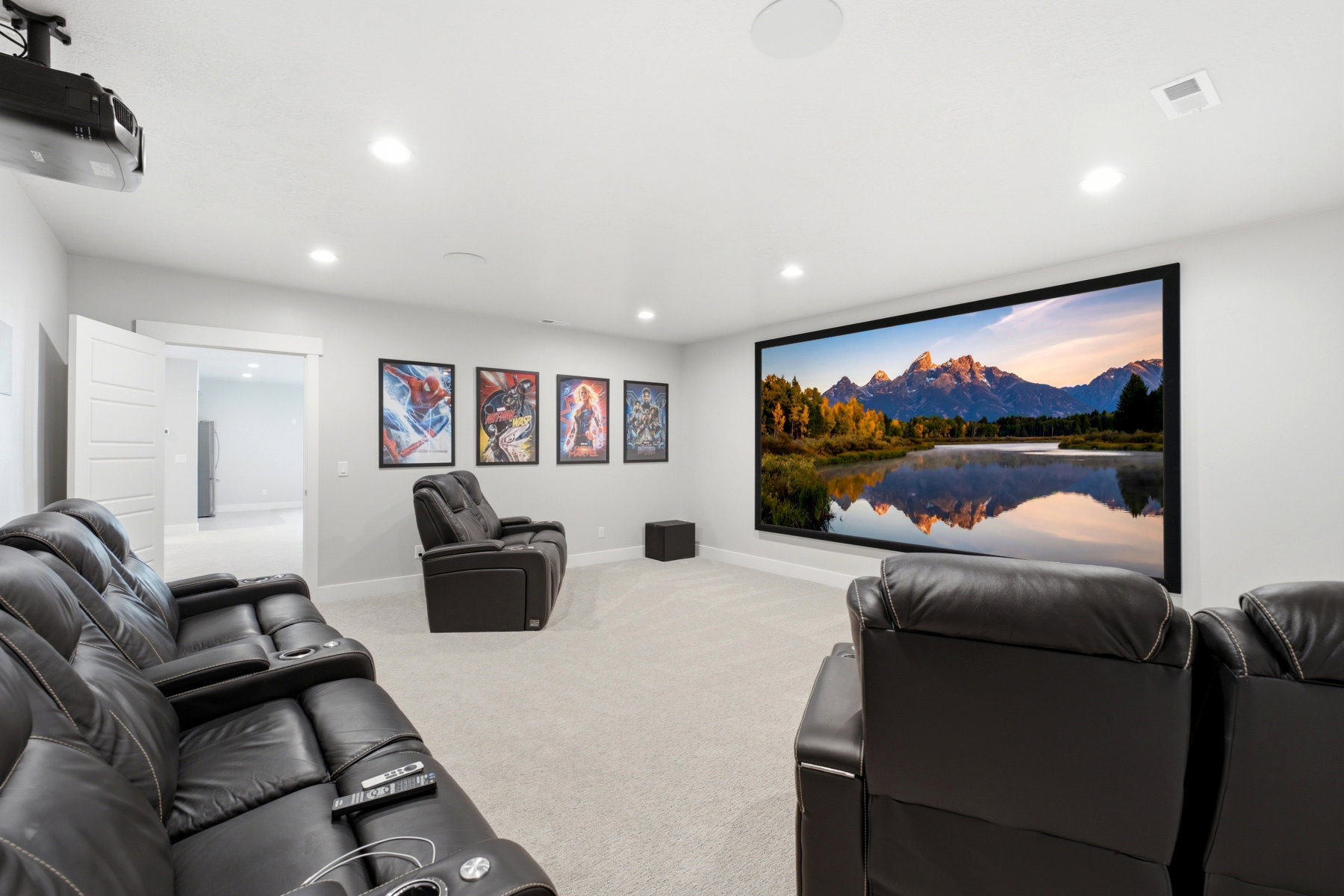 Dedicated home theater featuring a large projection screen, recessed lighting, and soft carpet flooring